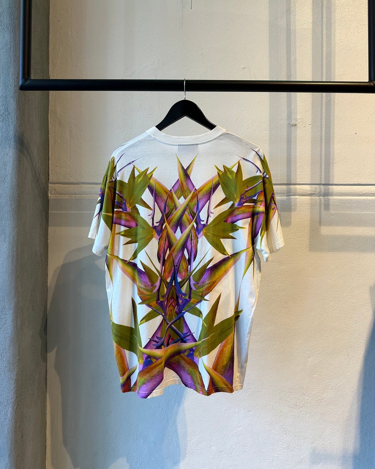 Model walking on a Givenchy runway wearing a colorful tropical-themed outfit.