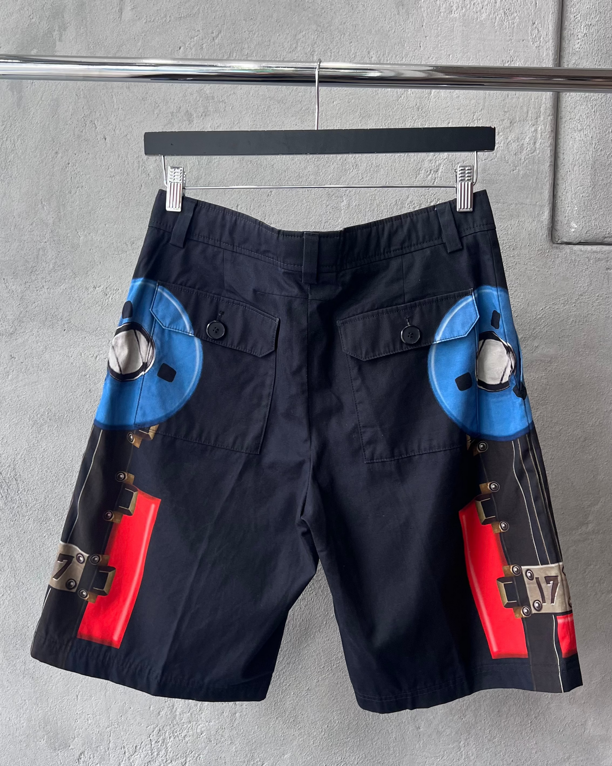 Black Givenchy shorts with colourful designs on a gray background