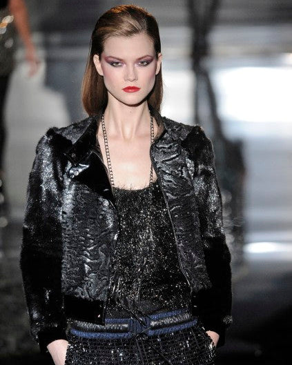 Model wearing a black sequined Gucci outfit on a runway