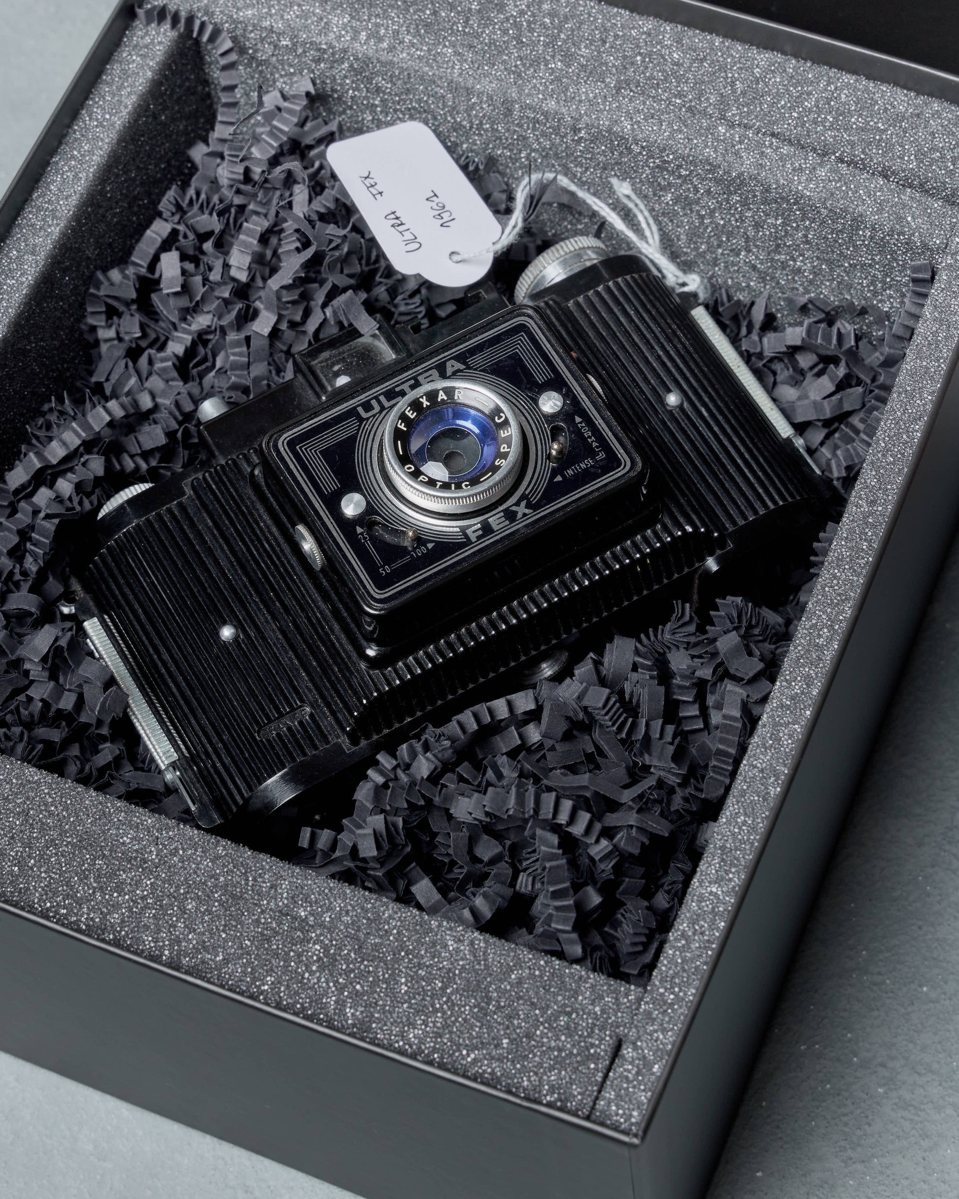 Vintage Gucci camera in a box with gray crinkle paper