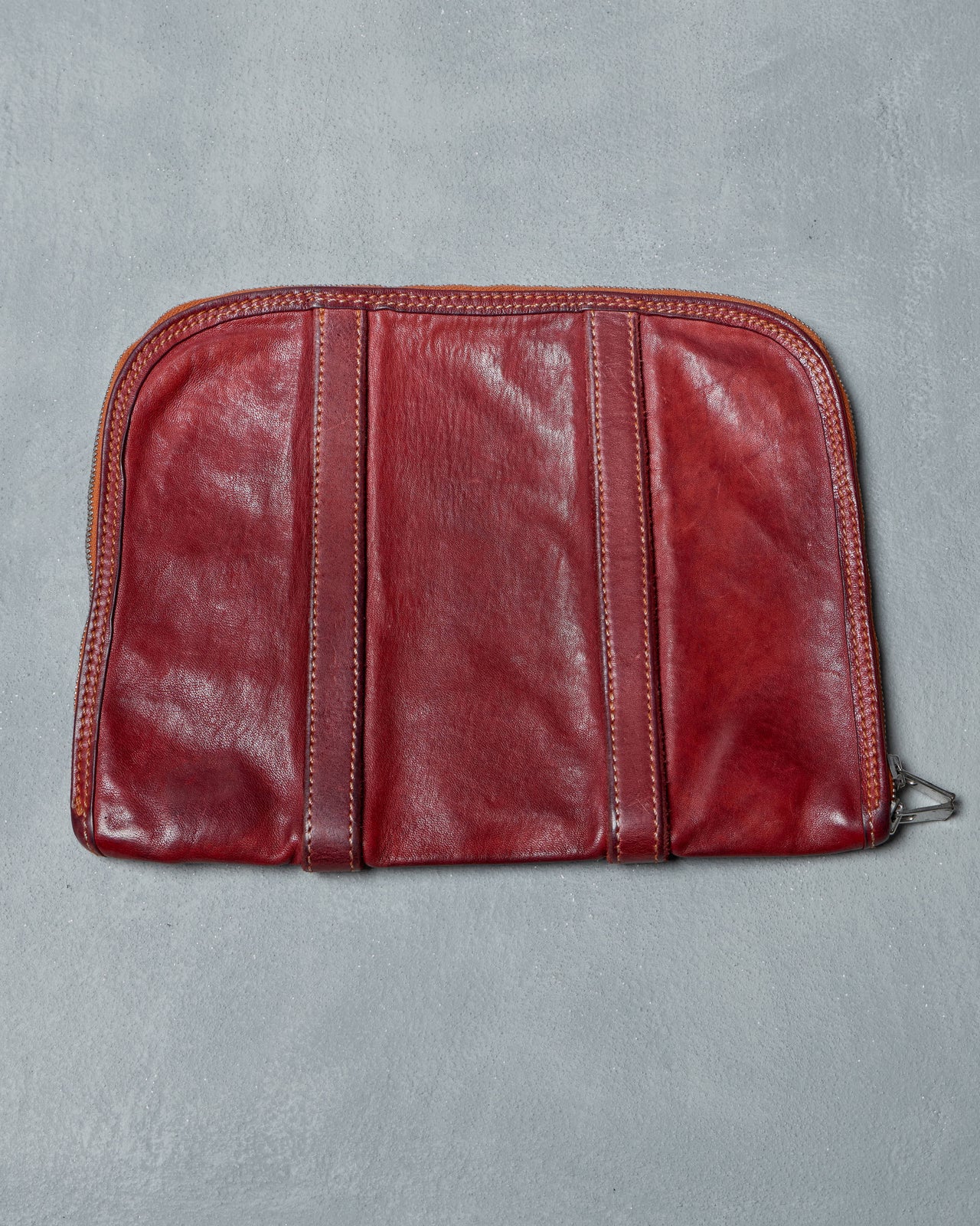 Red leather Guidi pouch on a gray background