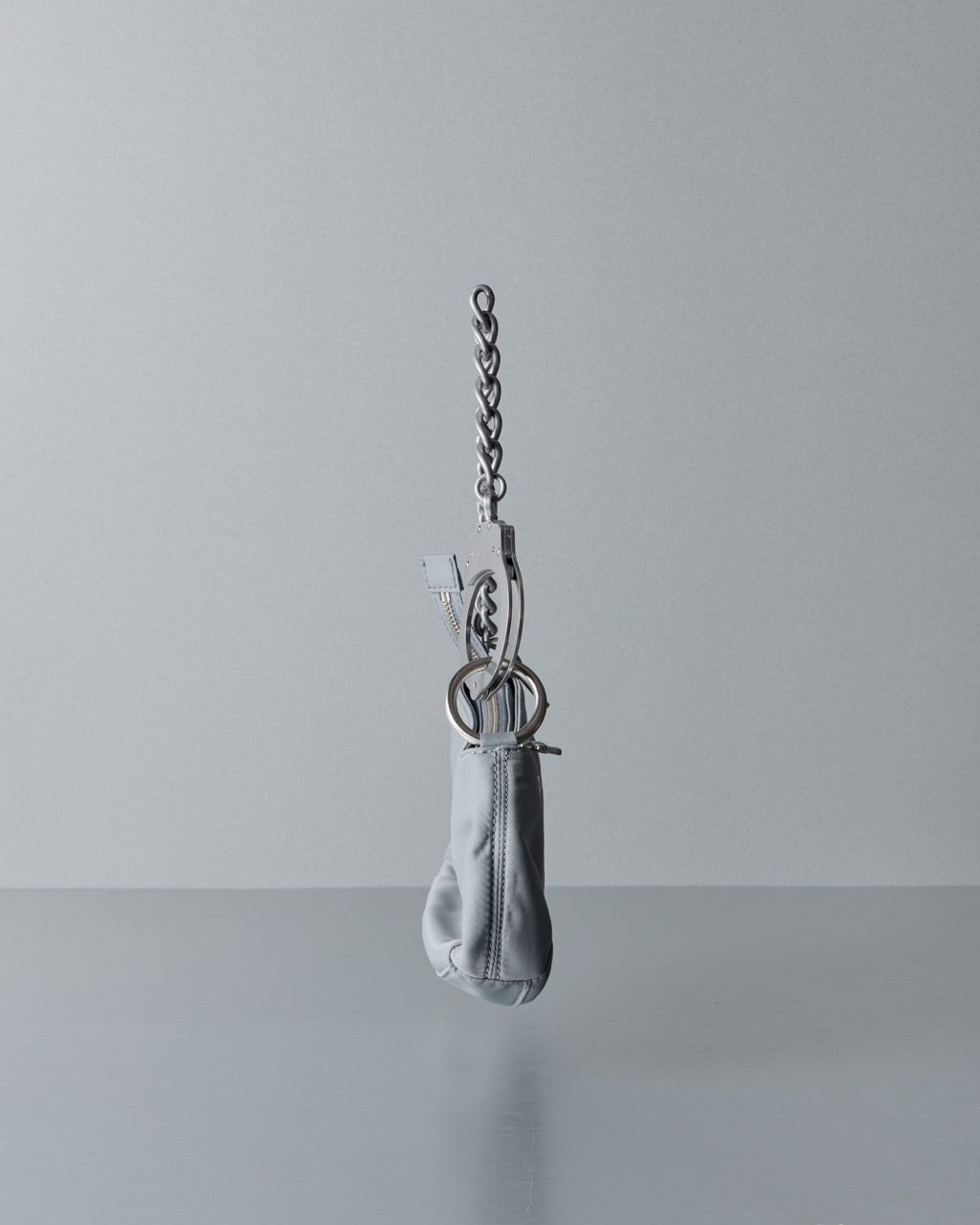 Metallic Marc Jacobs handbag with a small pouch on a gray background