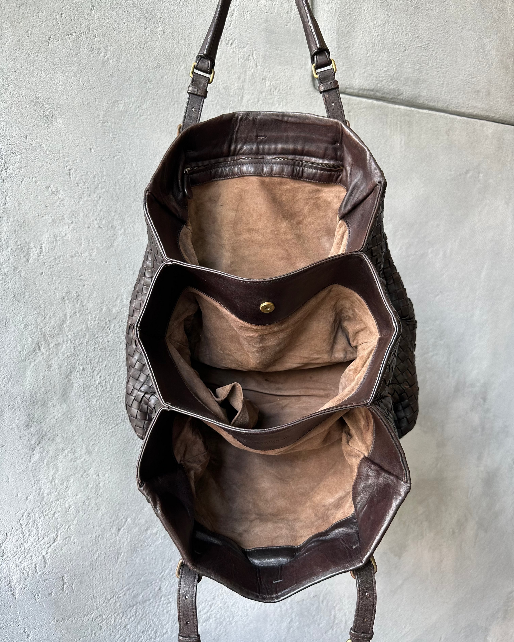 Brown leather Bottega Veneta bag with a textured surface on a light gray background