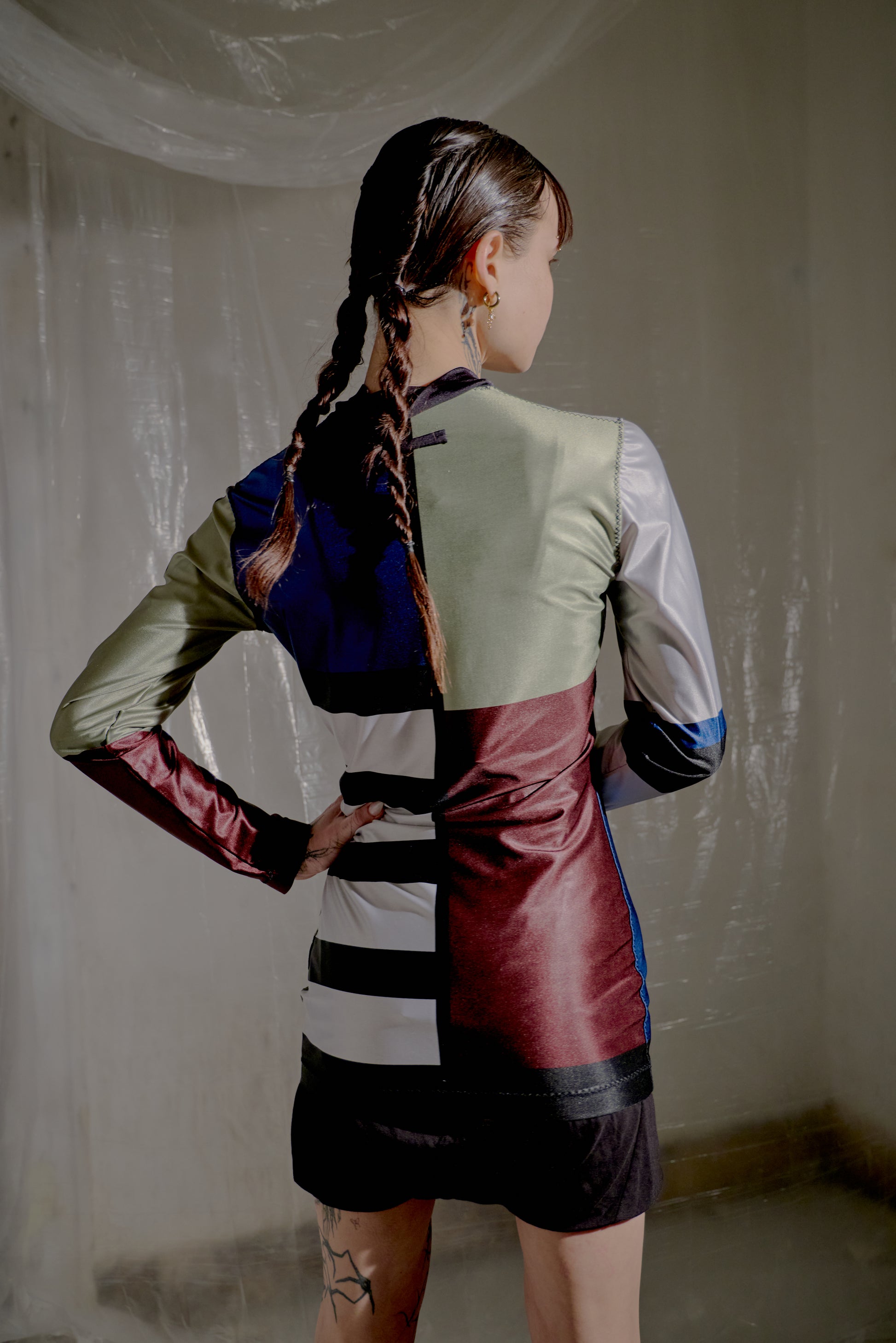 Person wearing a colourful Jean Paul Gaultier top with geometric pattern in an indoor setting