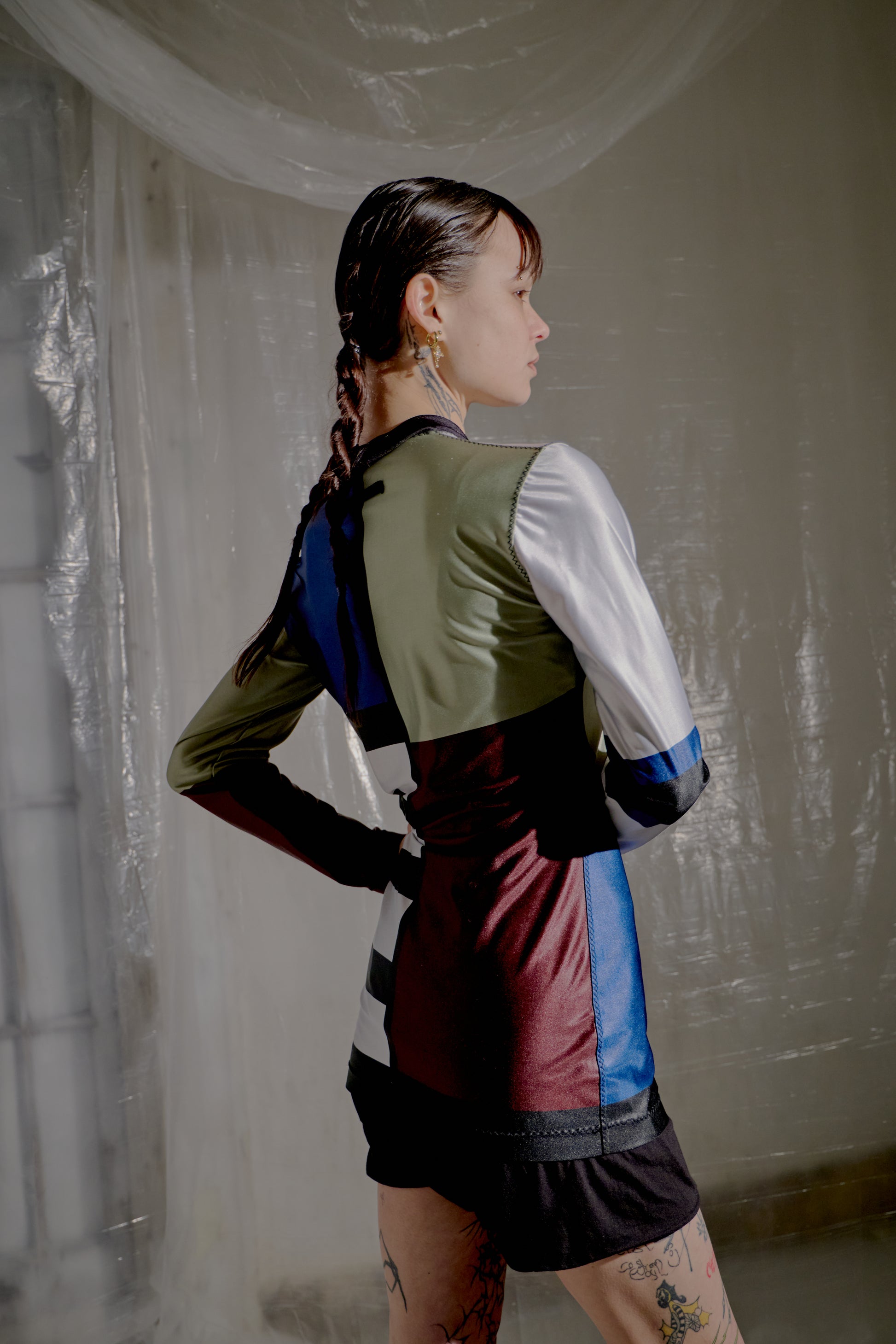 Person wearing a colourful Jean Paul Gaultier top in an indoor setting