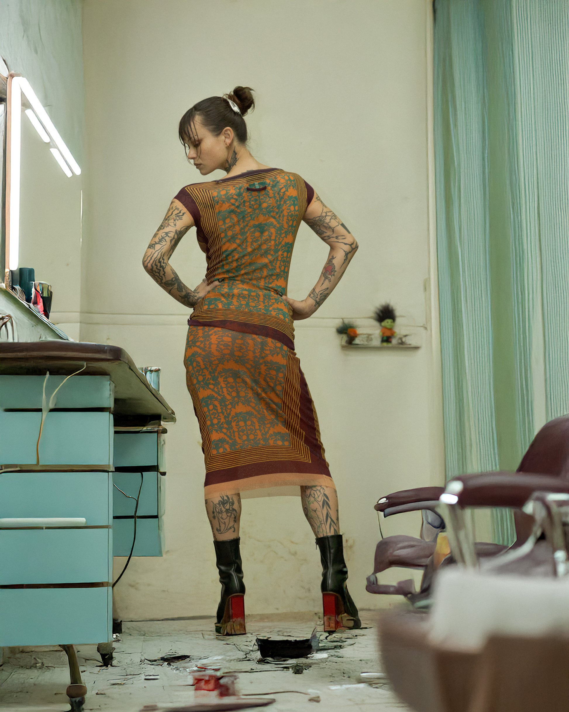Person wearing a patterned Jean Paul Gaultier dress standing in a vintage salon.