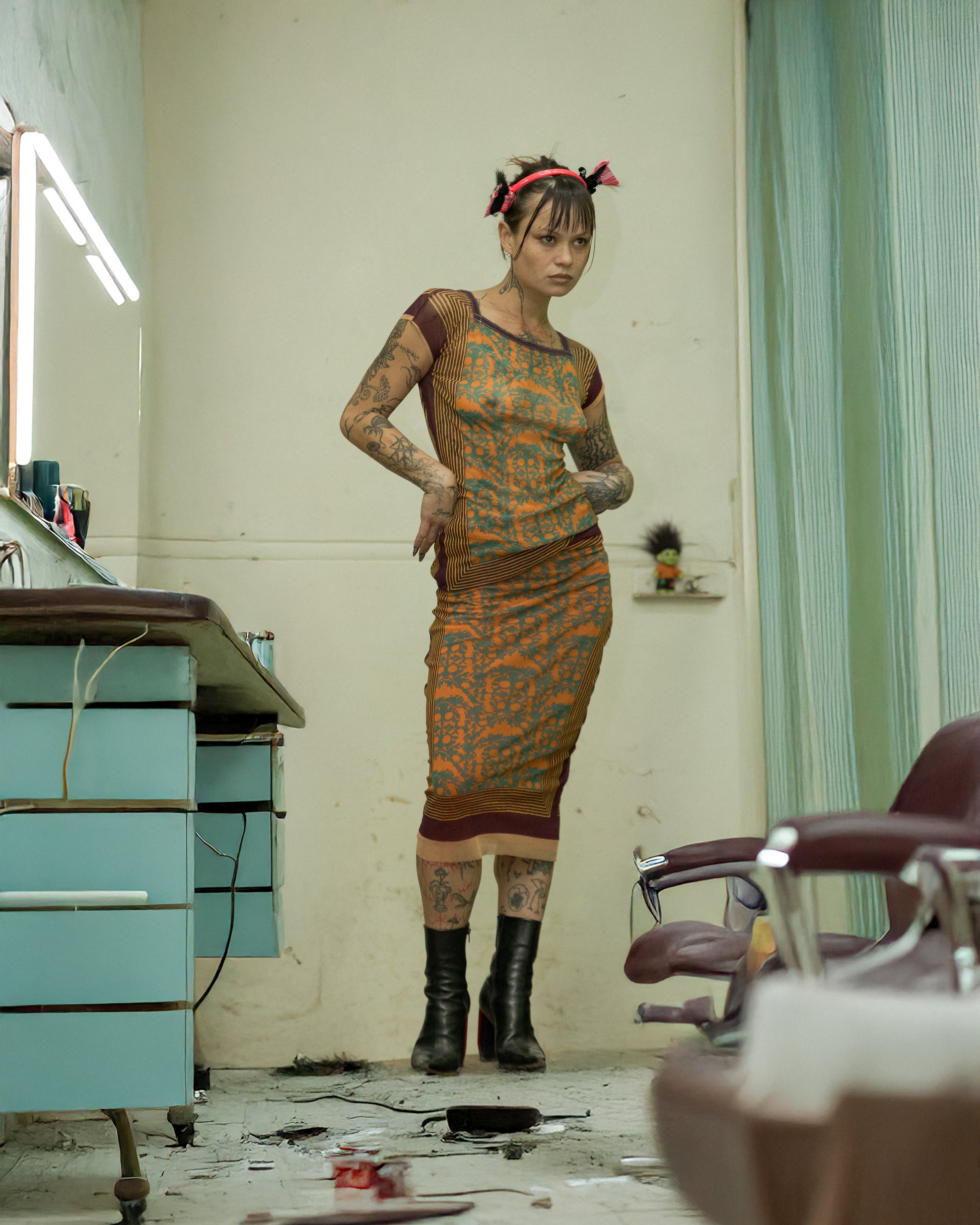 Woman in a patterned Jean Paul Gaultier top and skirt set standing in a room with medical or salon equipment.