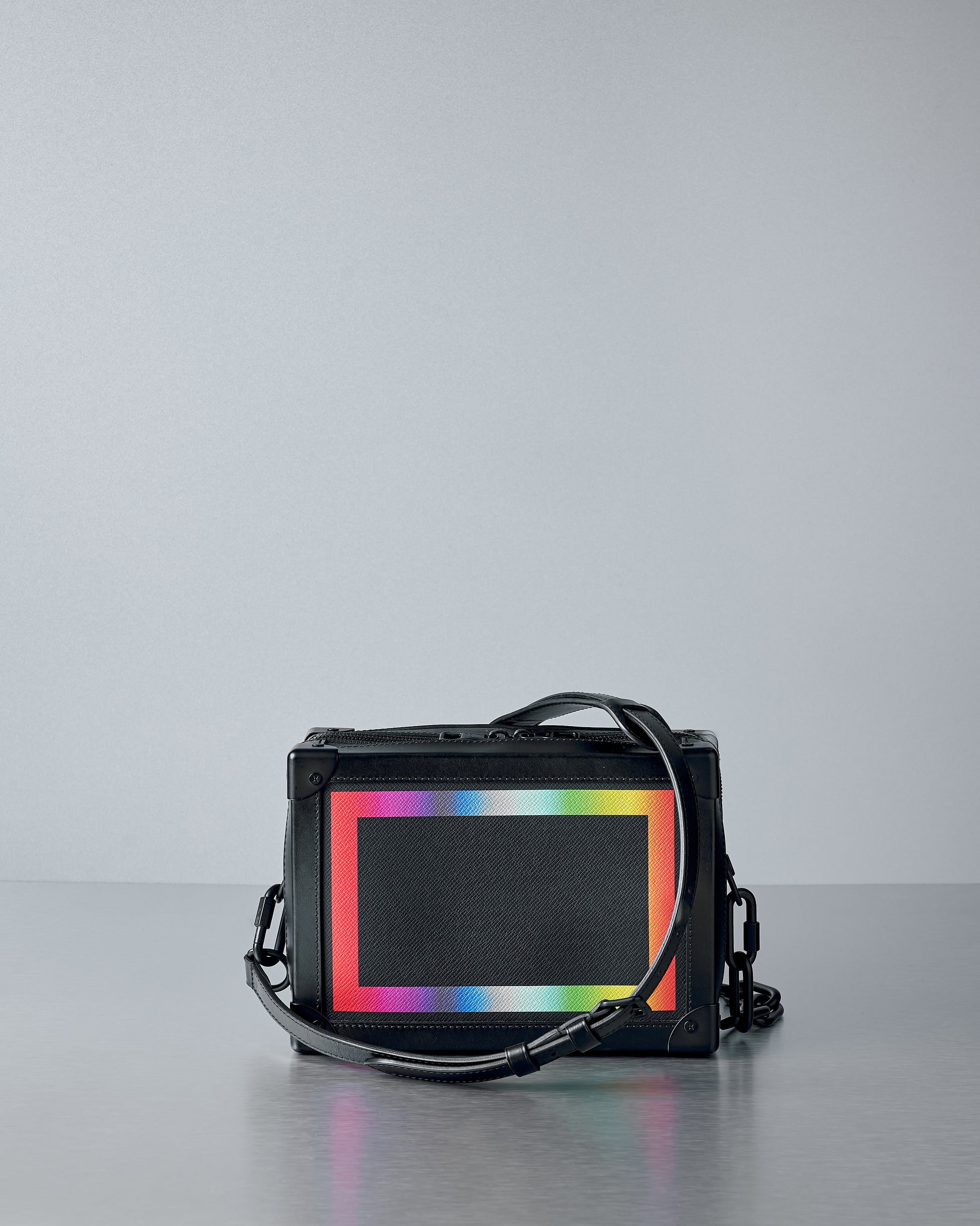 Black Louis Vuitton bag with a colourful screen on a gray background