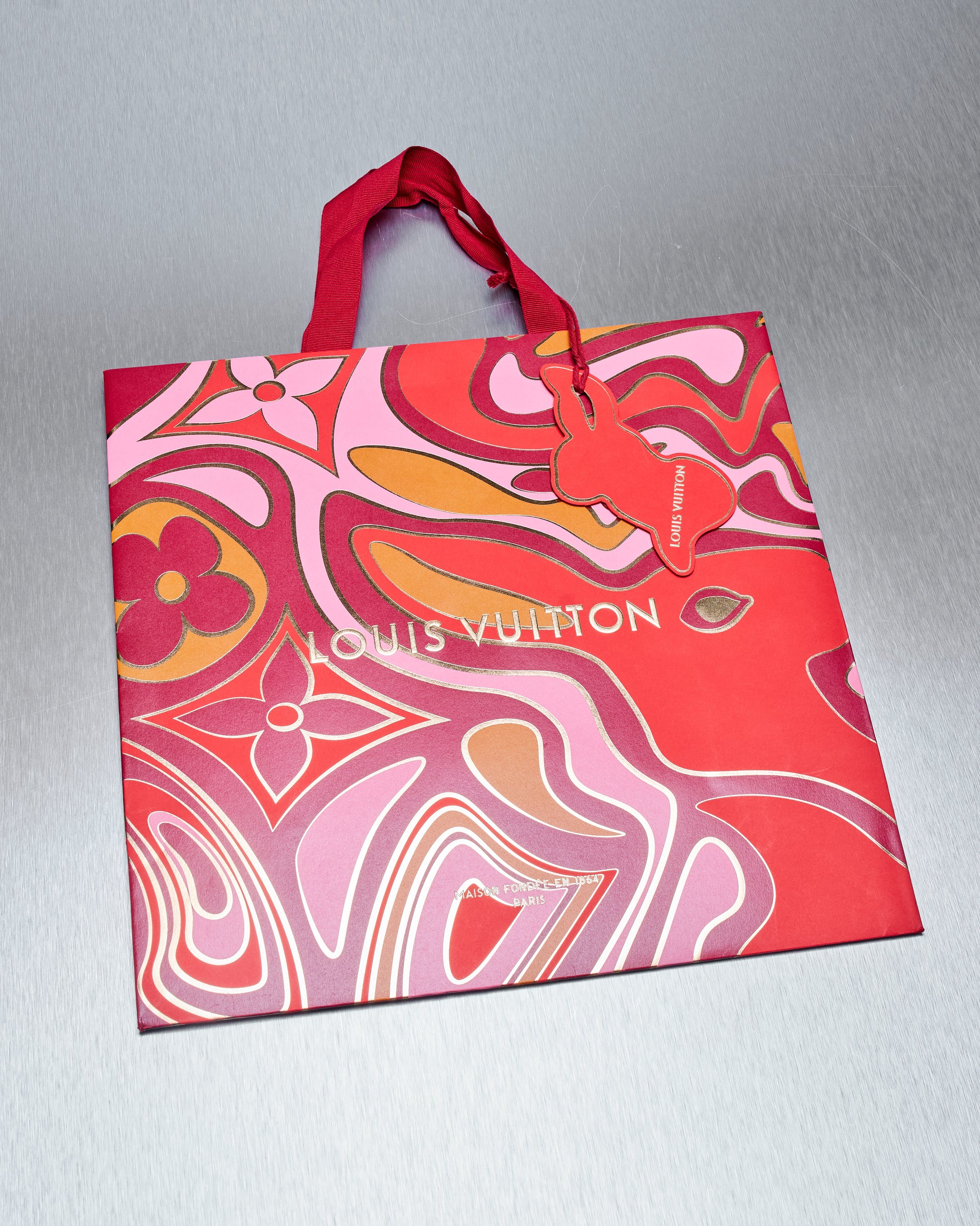 Louis Vuitton carry bag with colourful abstract design on a gray background