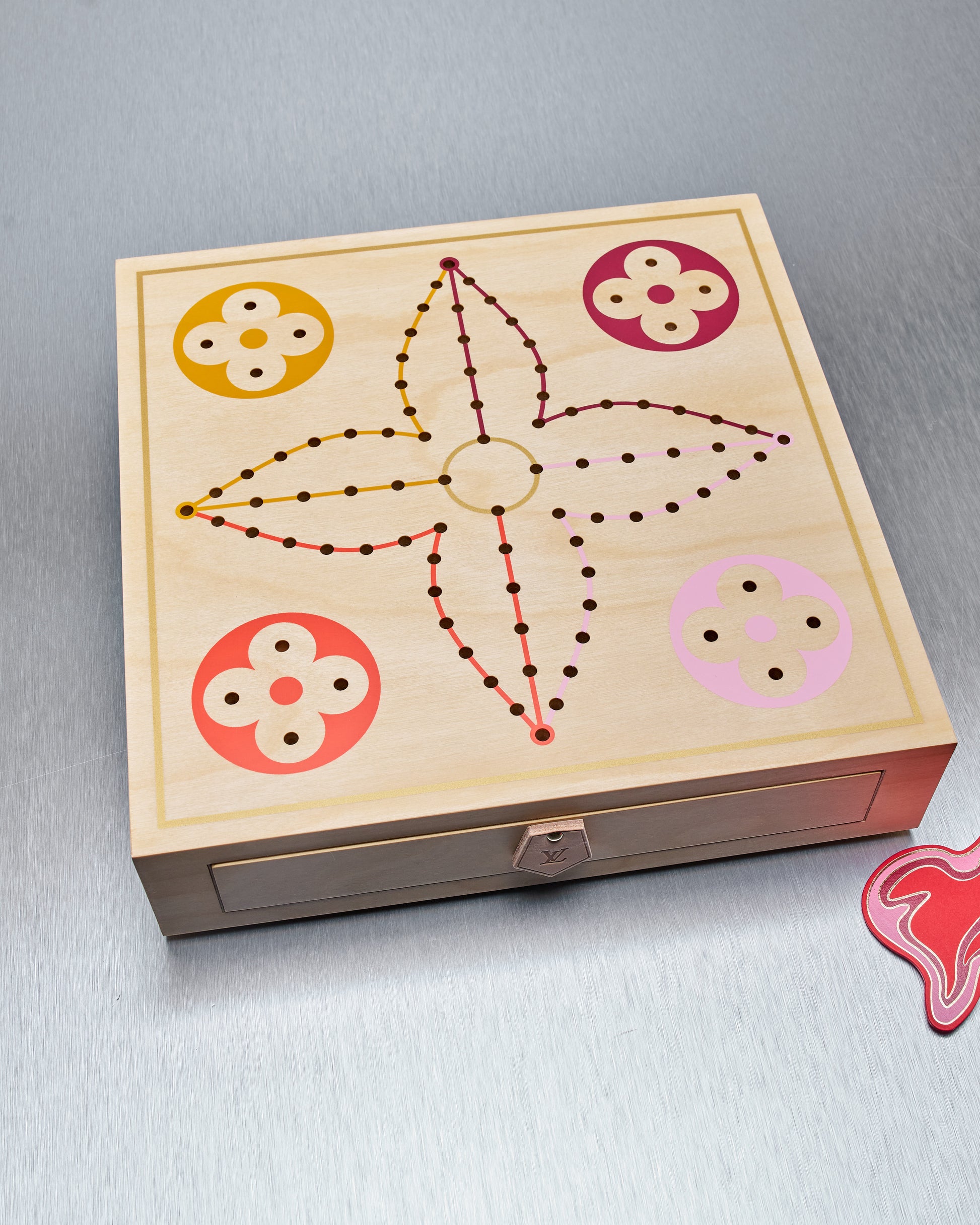 Wooden Louis Vuitton board game with star design and colored circles on a gray background
