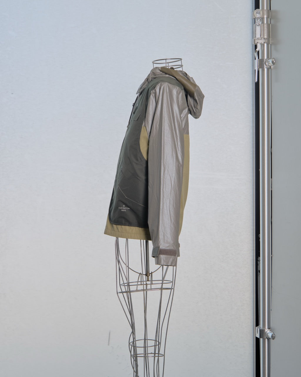 Silver Louis Vuitton jacket on a mannequin against a light gray background