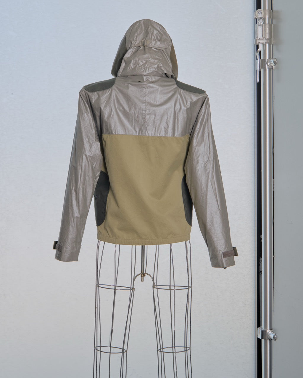 Two-tone Louis Vuitton jacket with metallic silver and beige sections on a mannequin against a light gray background.