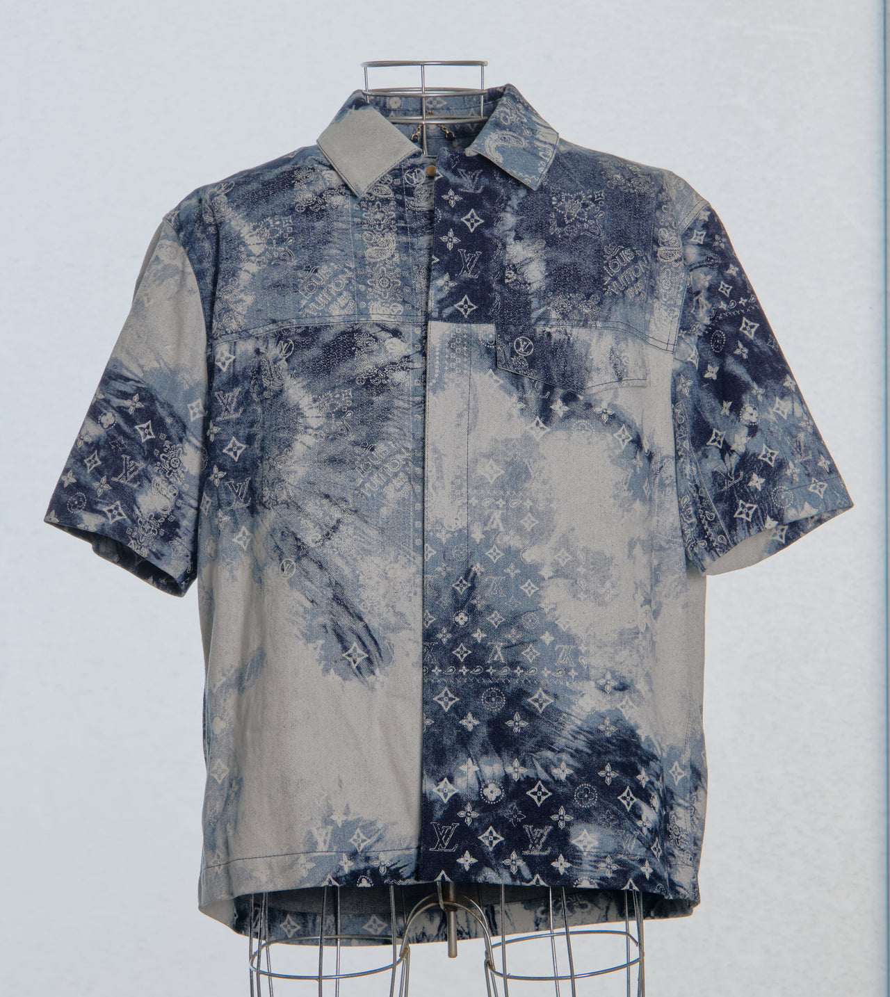 Short-sleeve Louis Vuitton shirt with a pattern on a mannequin against a light blue background