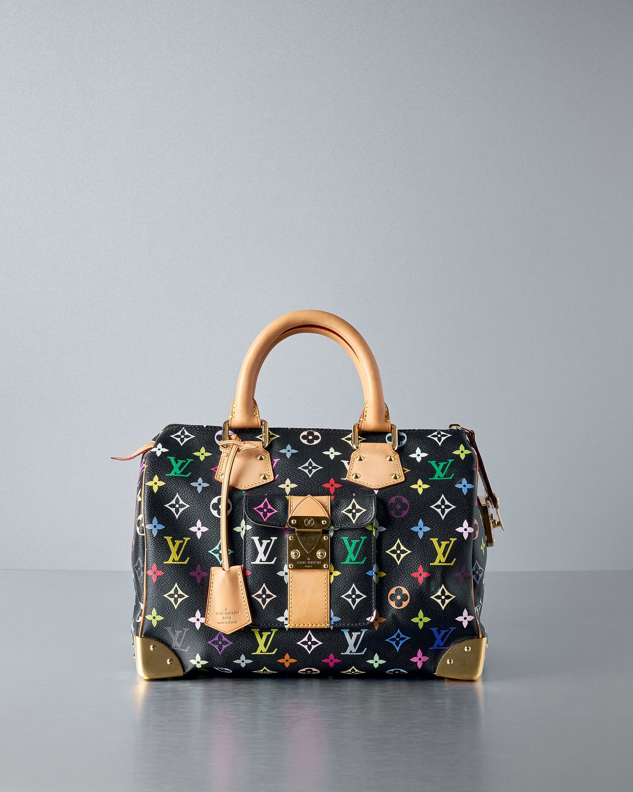 A multicoloured Louis Vuitton Speedy 30 top-handle bag with tan leather detailing and gold hardware.