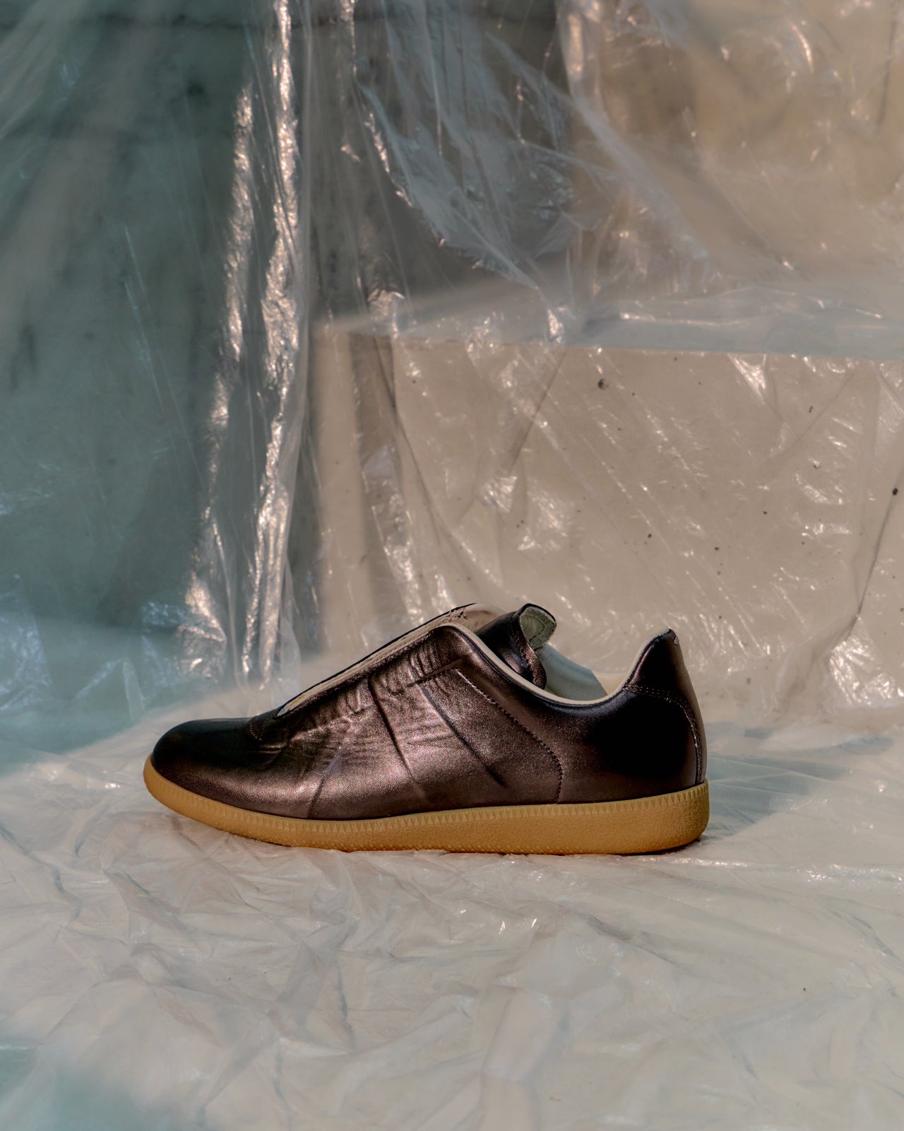 Brown Maison Margiela shoe with a yellow sole on a transparent plastic sheet