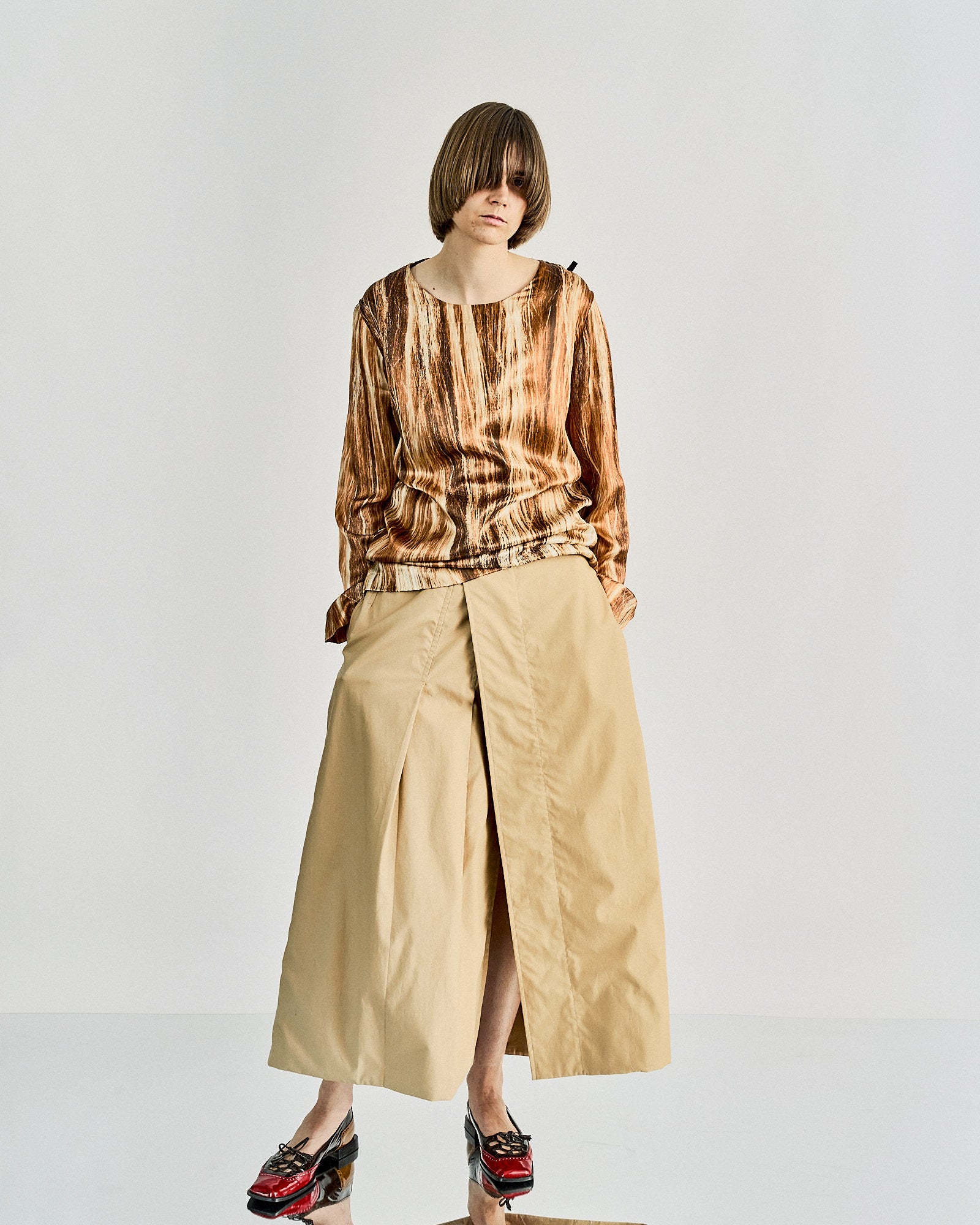 A longsleeve top from Maison Margiela with a round neckline and open cuffs, featuring a close-up of flowing strands of 'real hair' printed on the front.