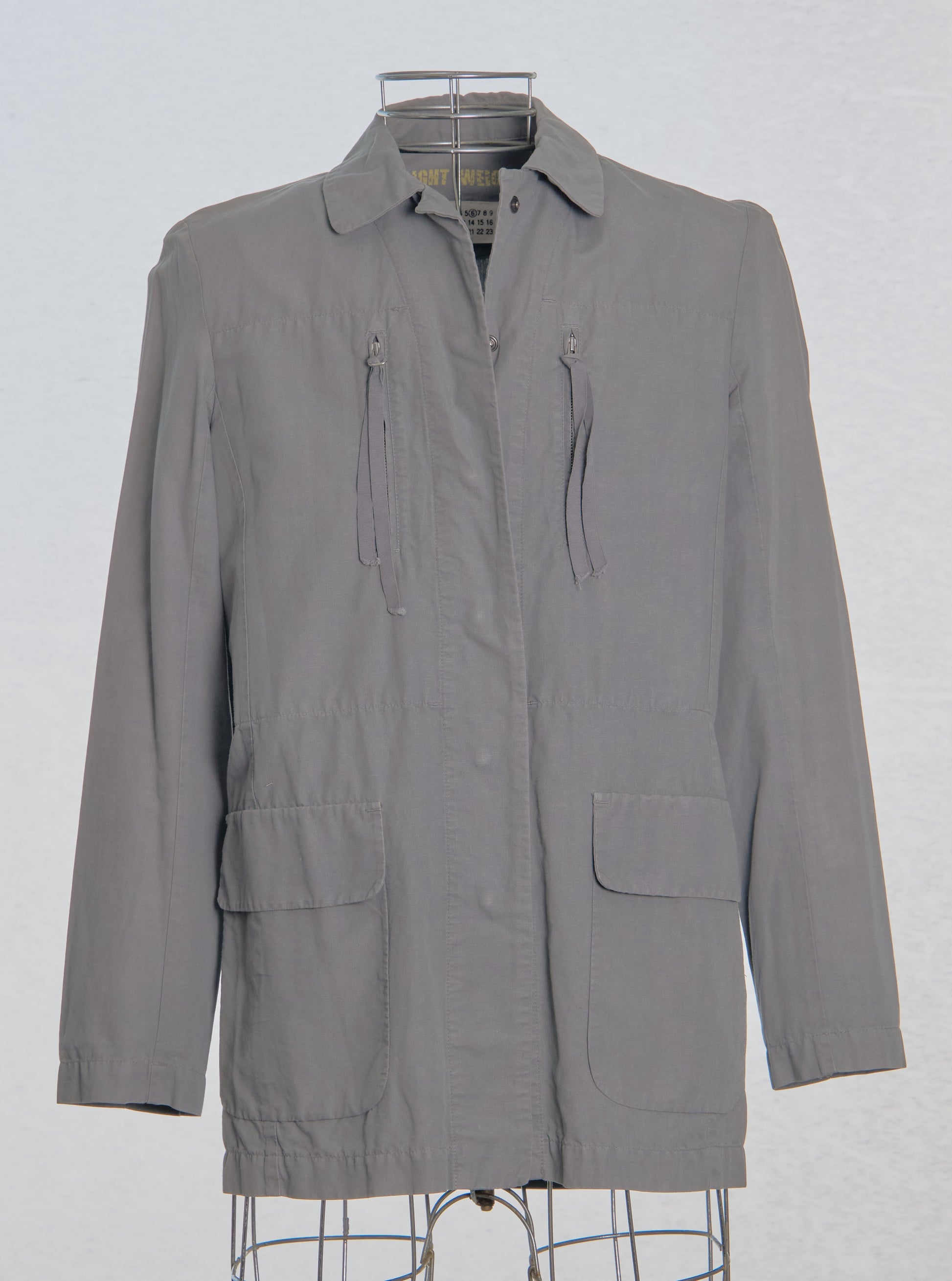 Gray Maison Margiela jacket on a hanger against a white background