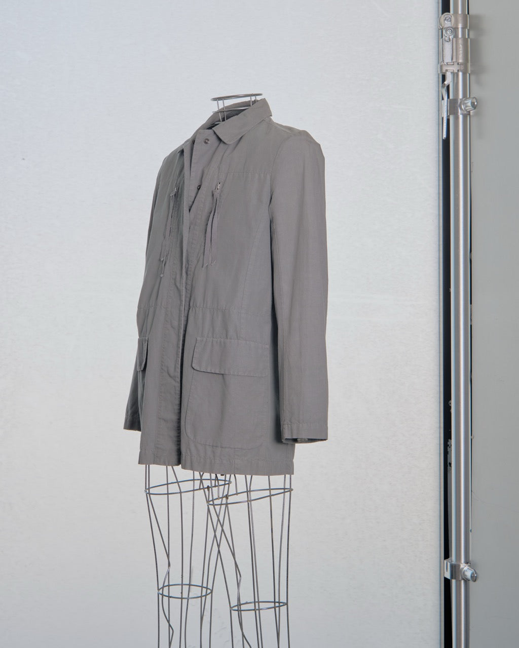 Gray Maison Margiela jacket on a hanger against a white background