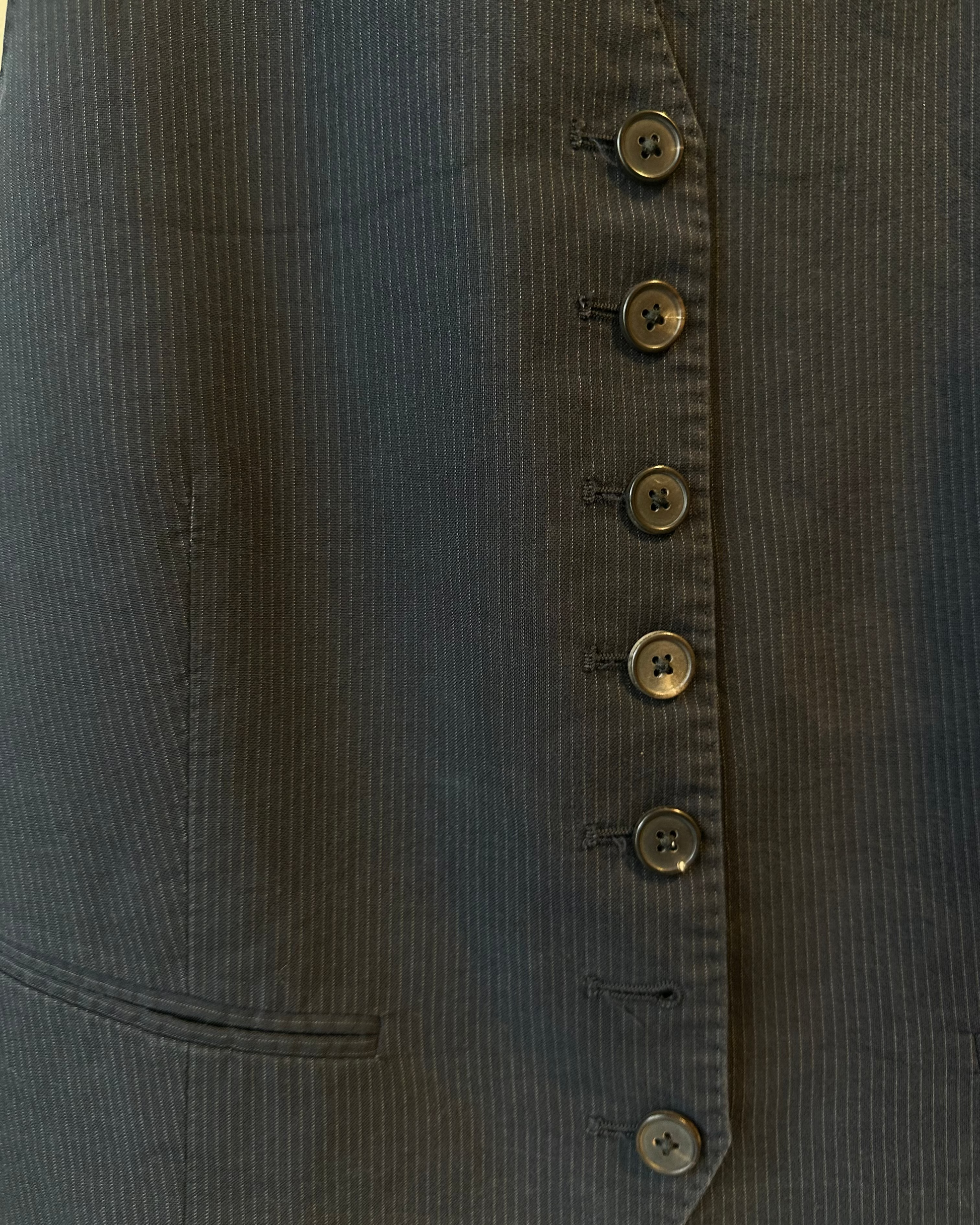 Close-up of a dark blue pinstripe Maison Margiela jacket with button details