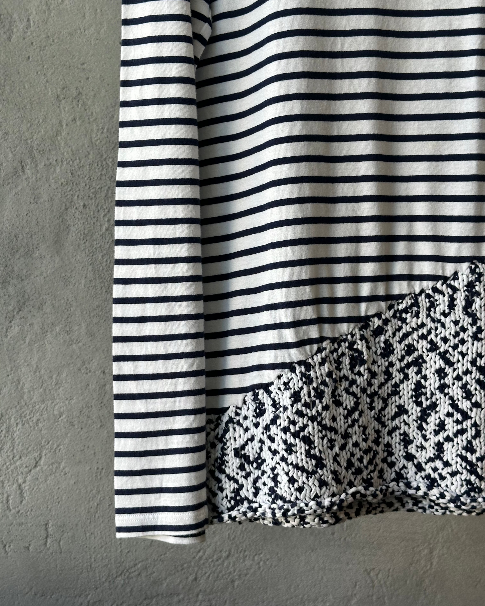 Close-up of a blue and white striped fabric with a textured pattern on a gray background