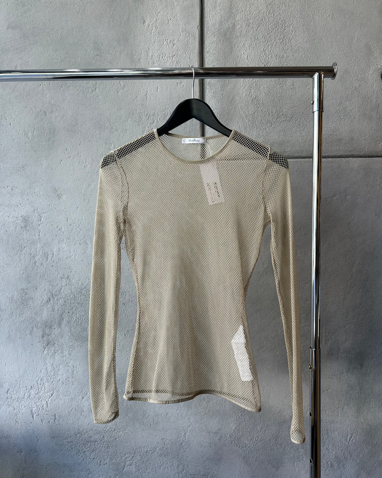 Beige long-sleeve Max Mara mesh top on a hanger against a gray wall