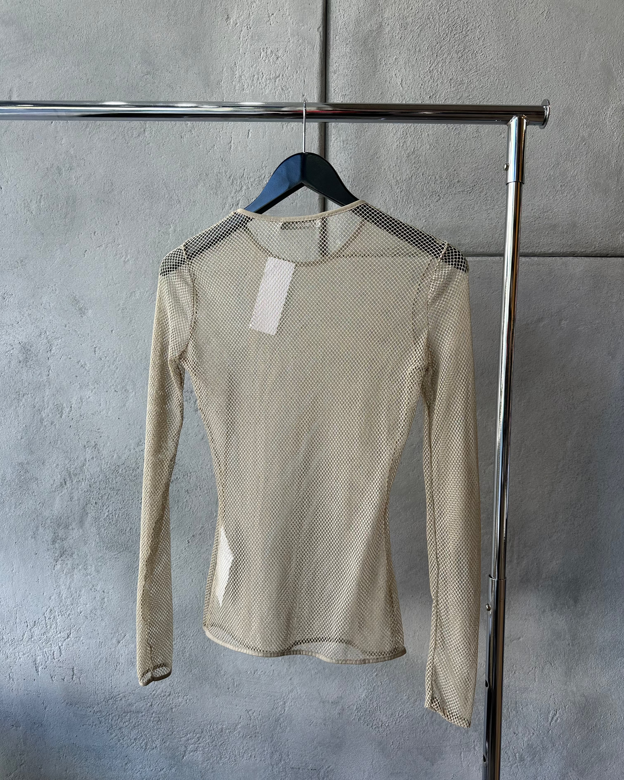 Beige long-sleeve Max Mara mesh top on a hanger against a gray wall