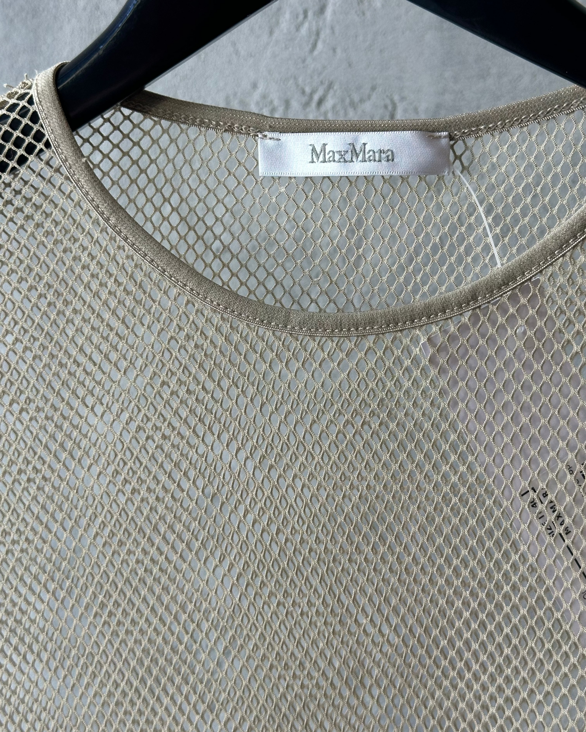 Close-up of a textured beige garment with 'MaxMara' label on a hanger.