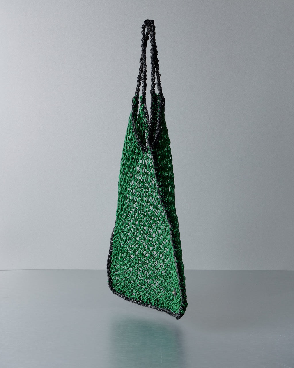 Green and black Max Mara  woven bag on a gray background