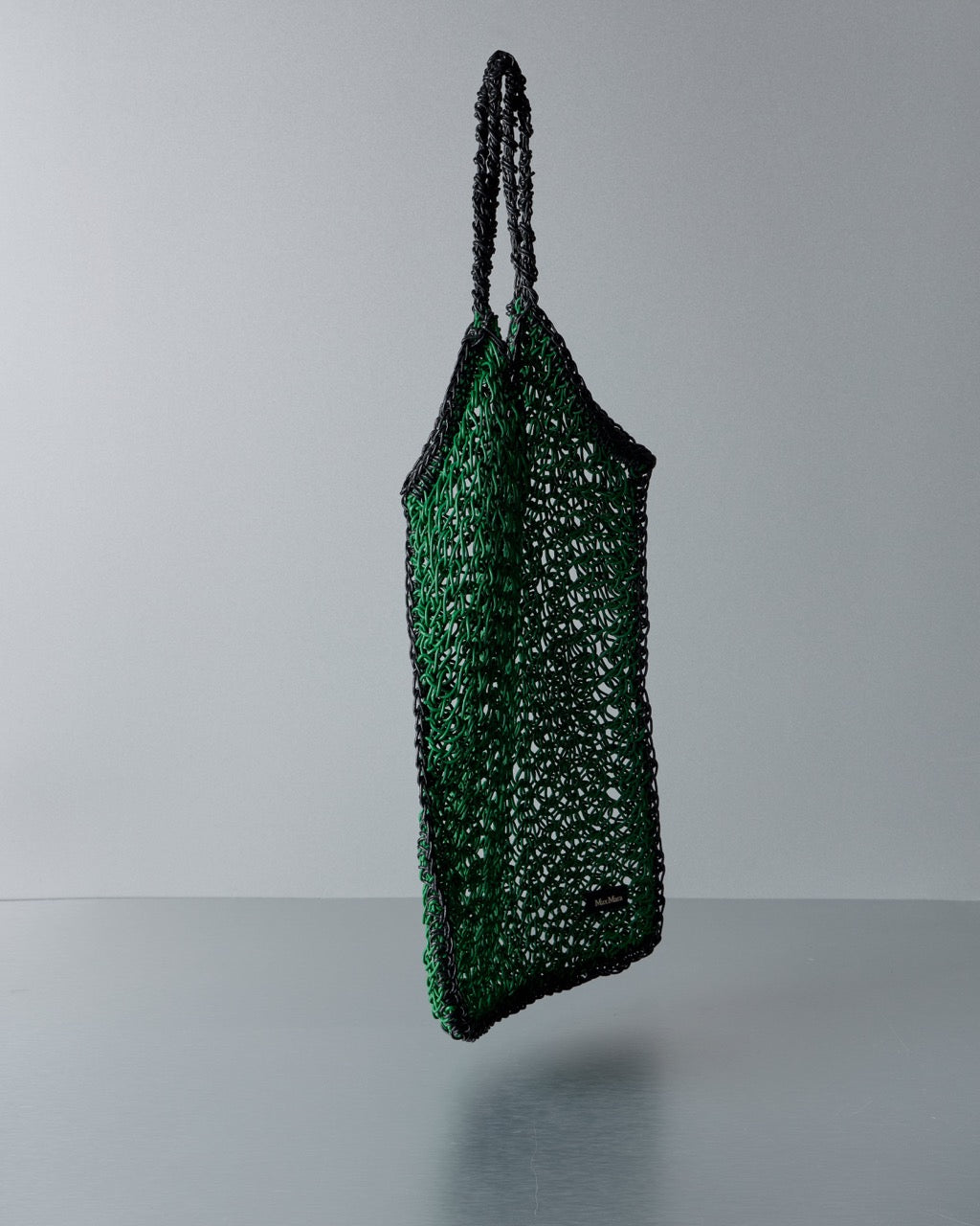 Green textured Max Mara handbag with black handles on a gray background