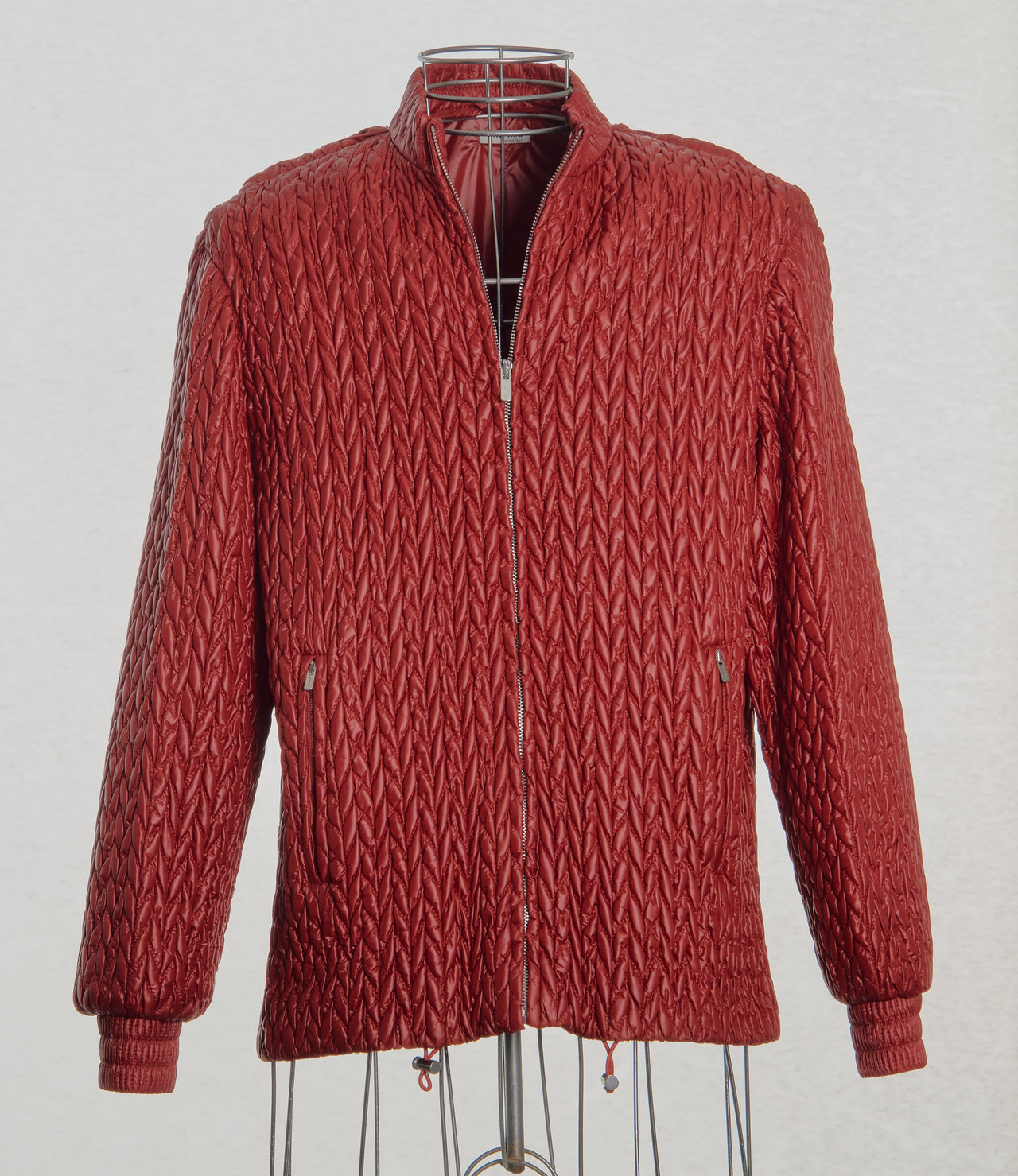 Red knitted Miu Miu puffer jacket on a mannequin against a white background