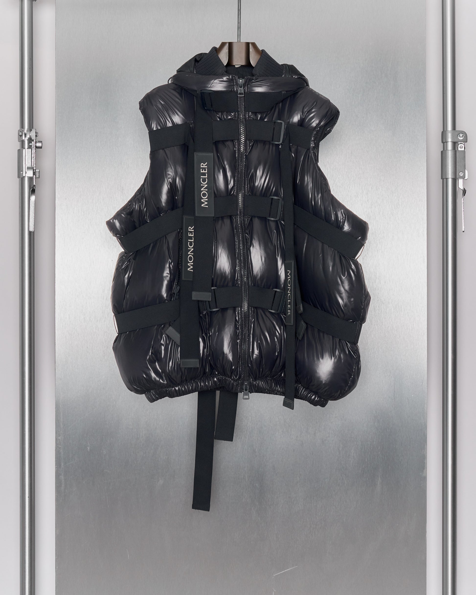 A black Moncler x Craig Green hooded gilet with elastic straps, ribbed collar and double-zip front.