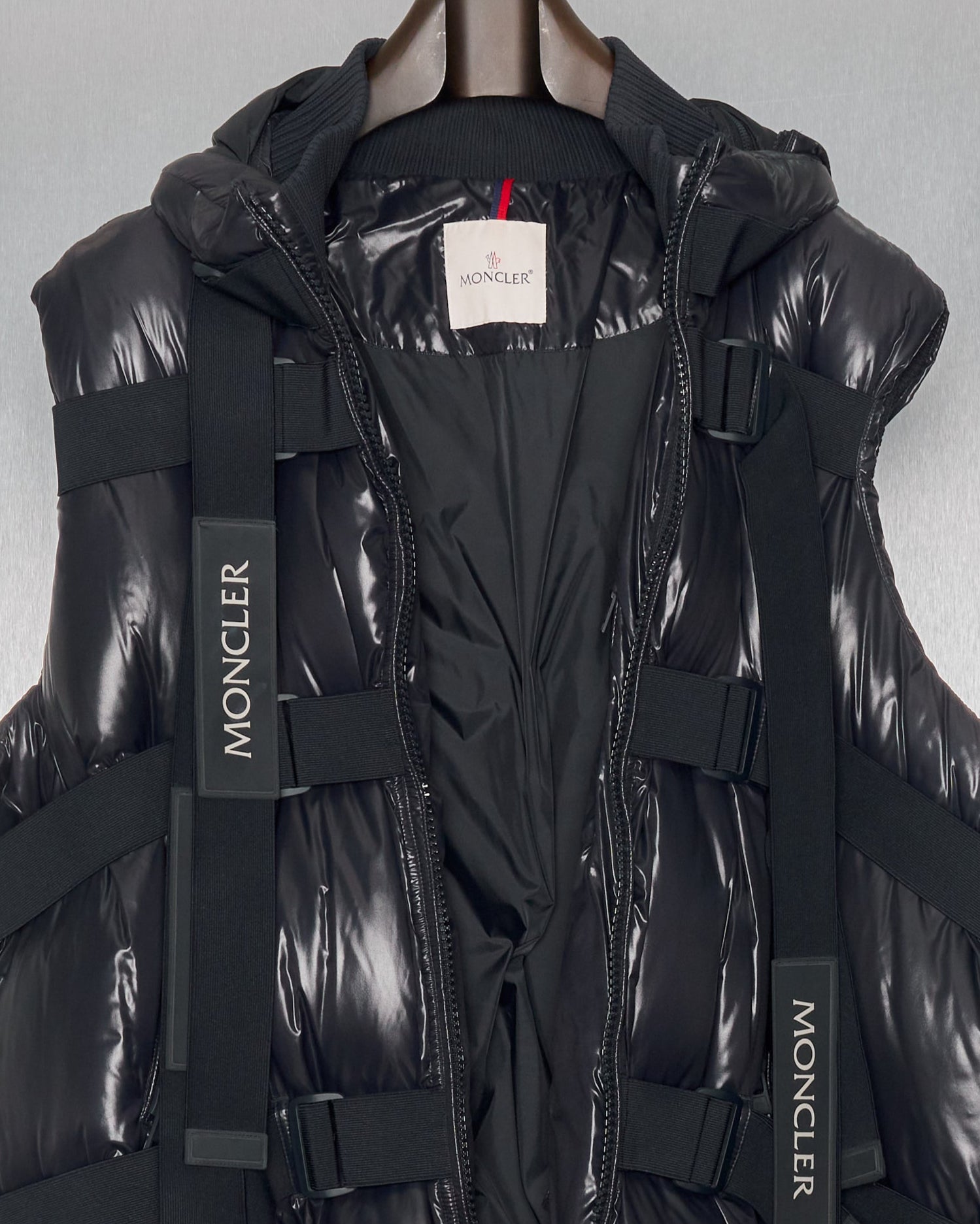 Black Moncler x Craig Green puffer jacket hanging against a grey background