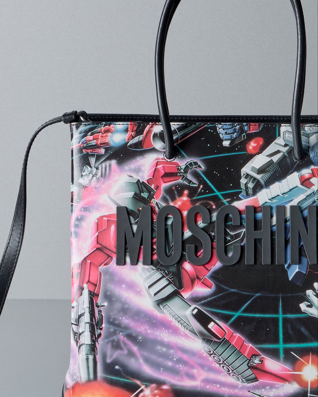 Multicoloured handbag with 'Moschino' branding on a gray background