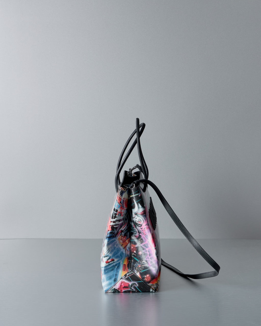 Multicoloued Moschino bag with black strap on a gray background