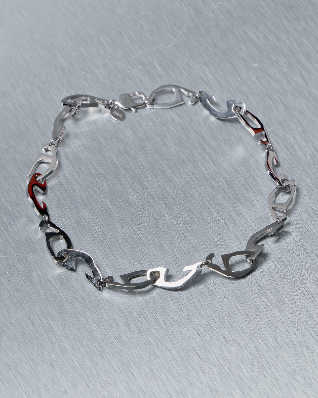 Silver Perks and Mini necklace on a textured gray background