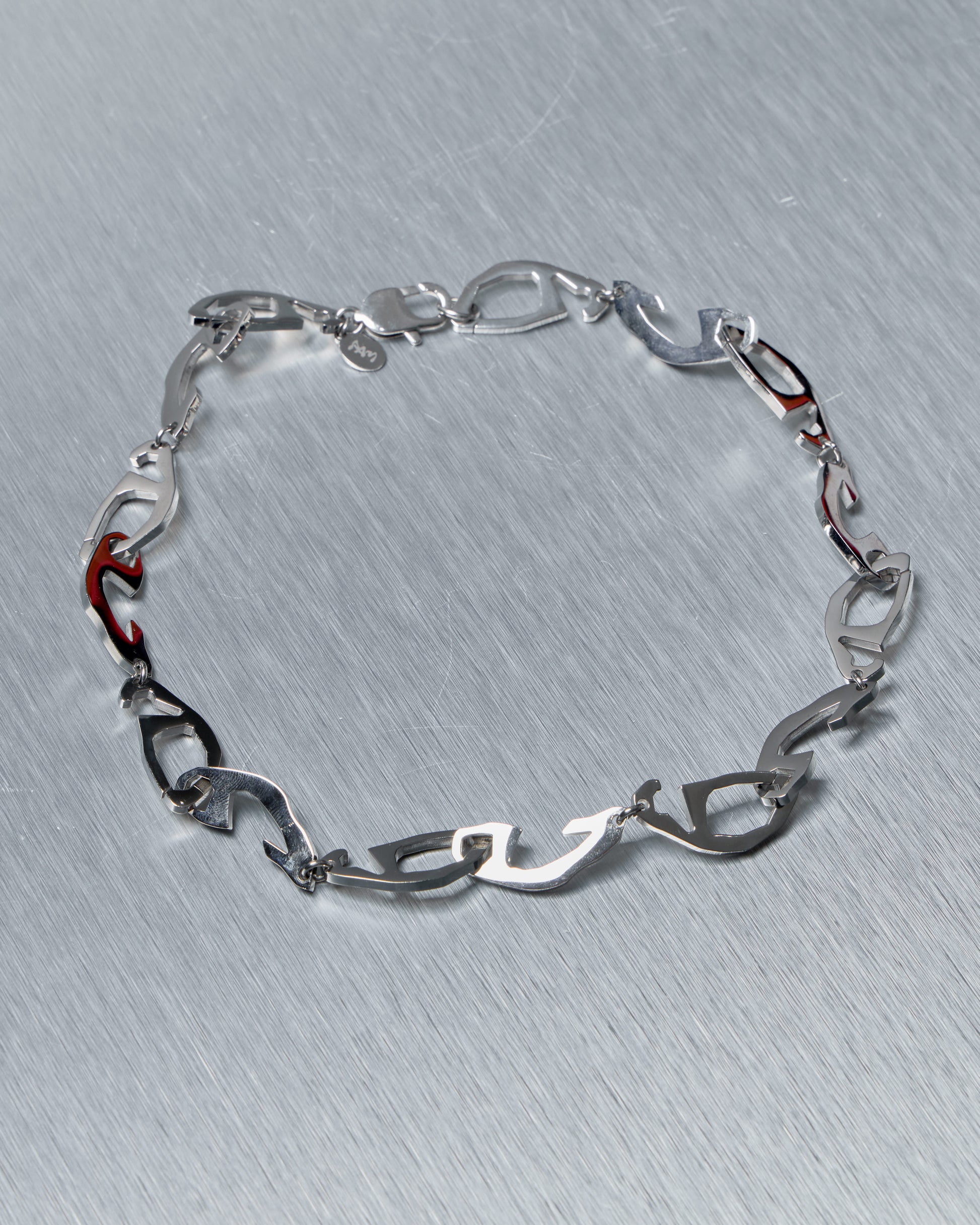 Silver Perks and Mini necklace on a textured gray background
