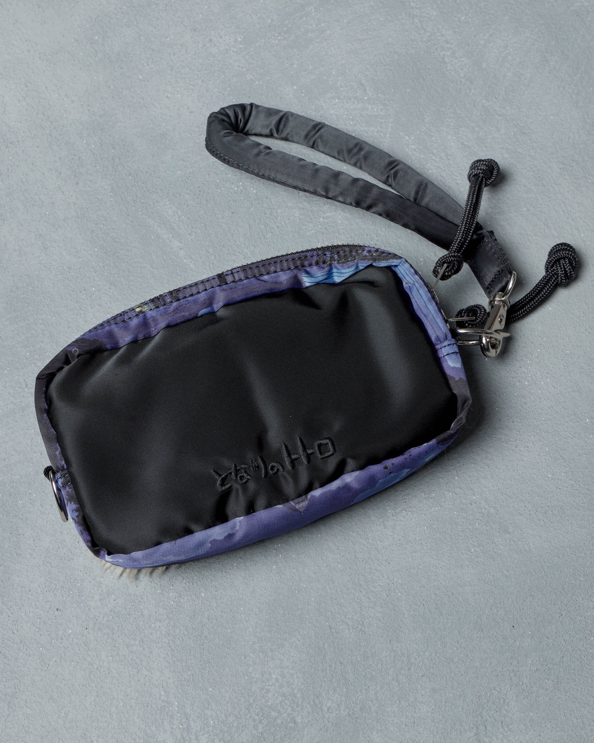 Black and purple Porter x Ghibli Totoro  pouch with a strap on a gray background
