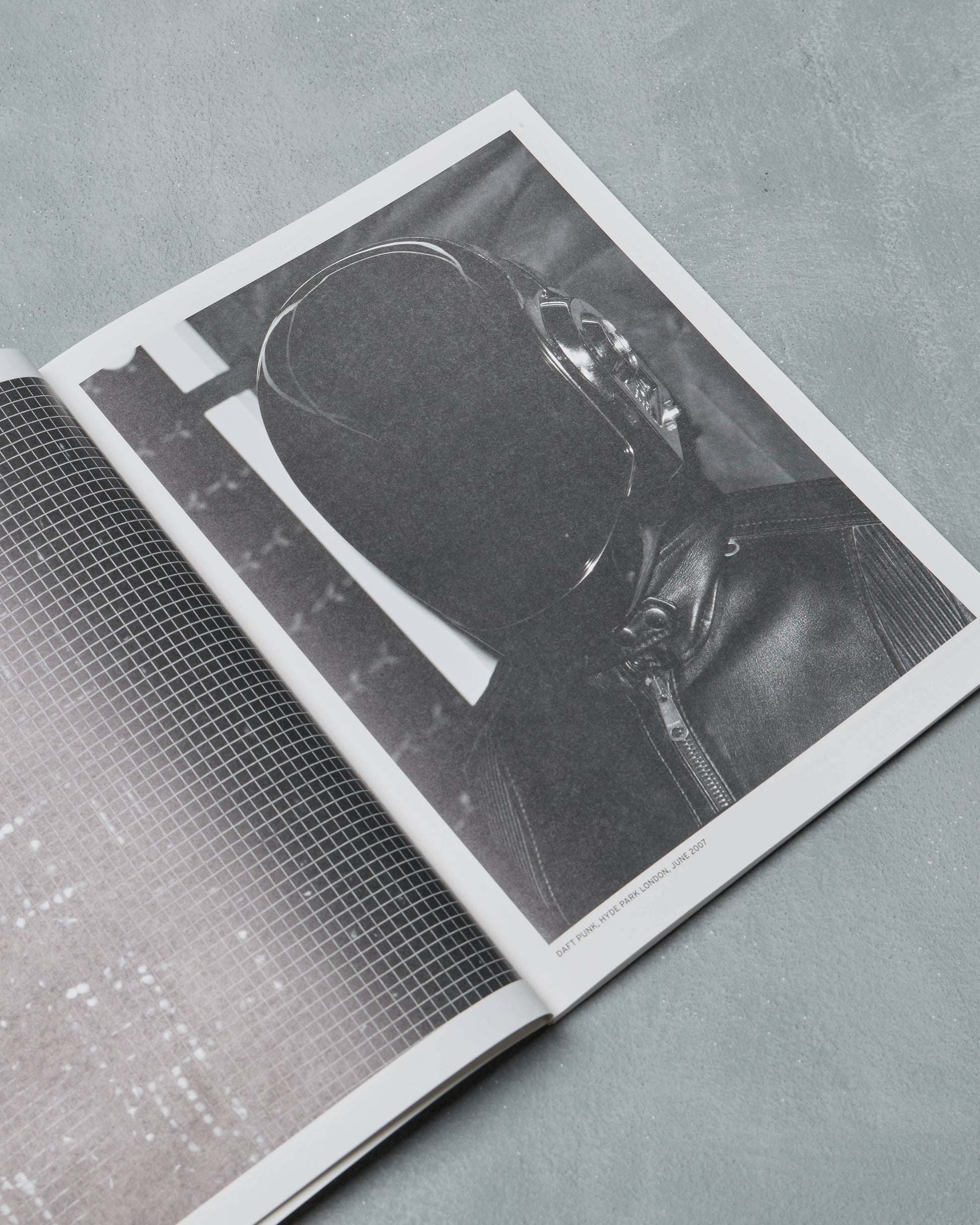 Open Ppaper Magazine with a black and white photograph of a person wearing a helmet on a gray surface