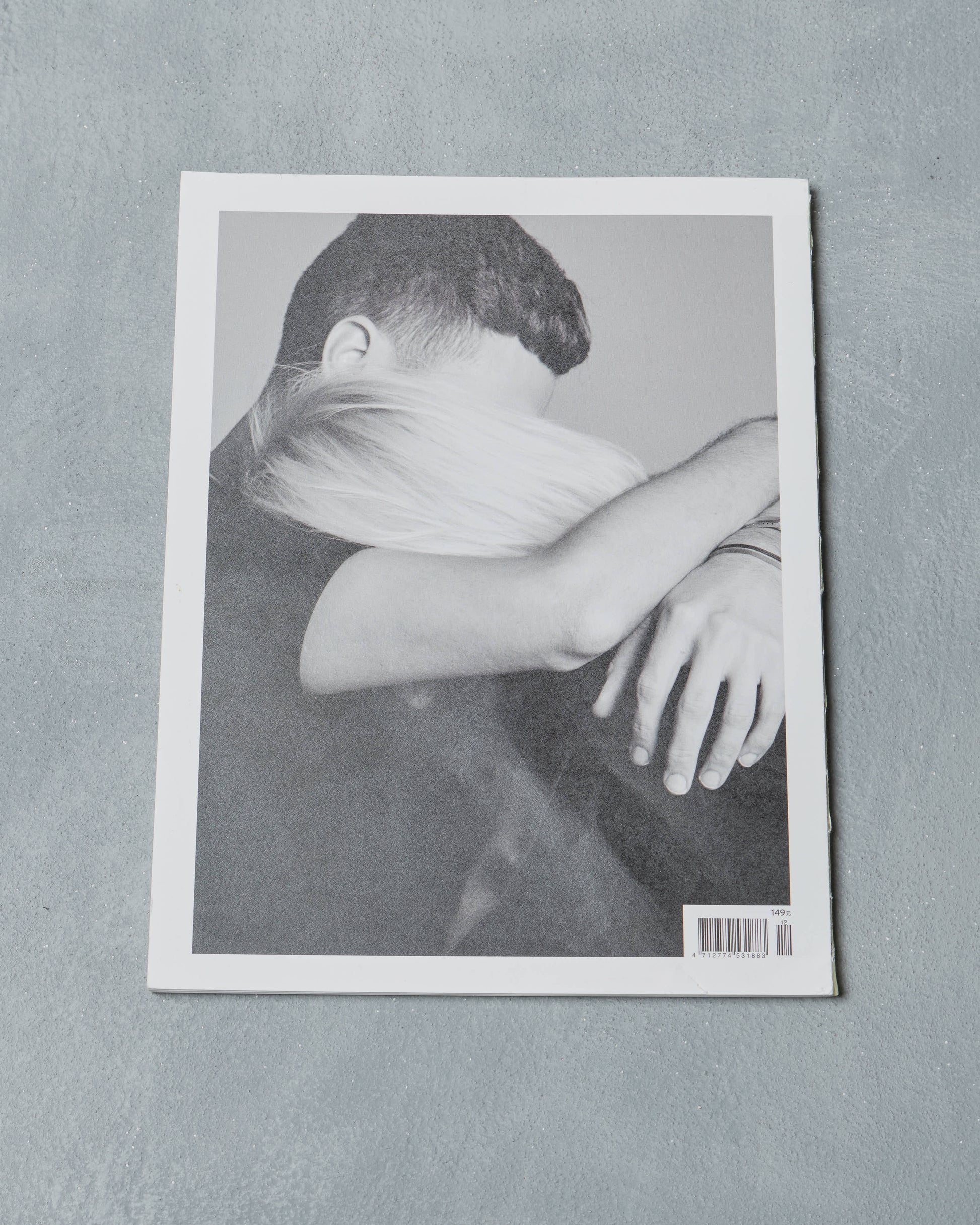 Reverse cover of a Ppaper Magazine showing a photo of a couple embracing on a gray background