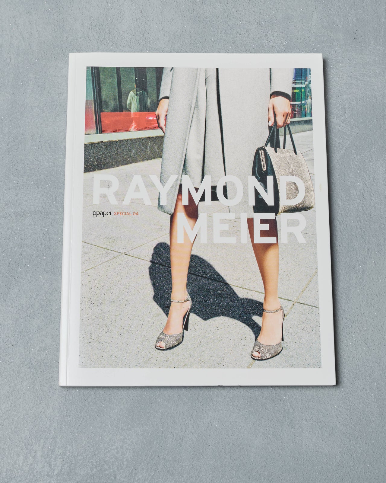 Ppaper Magazine for Raymond Meier with a person holding a handbag on a gray background