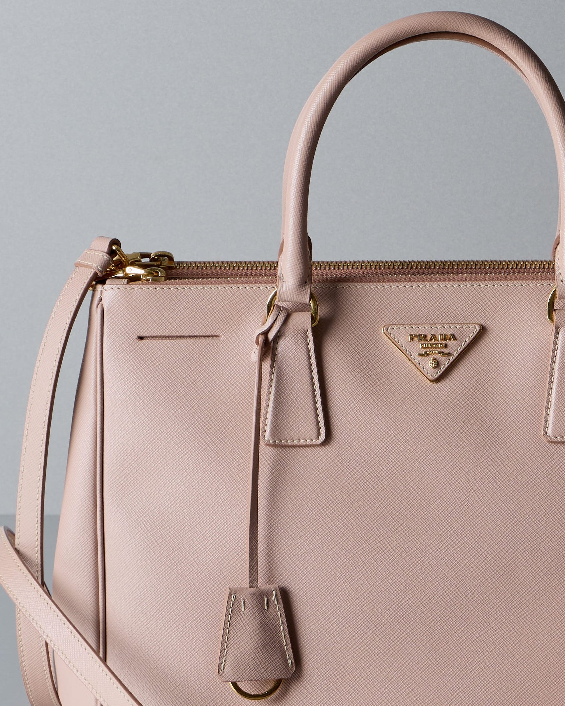 Pink Prada handbag with Prada logo on a gray background