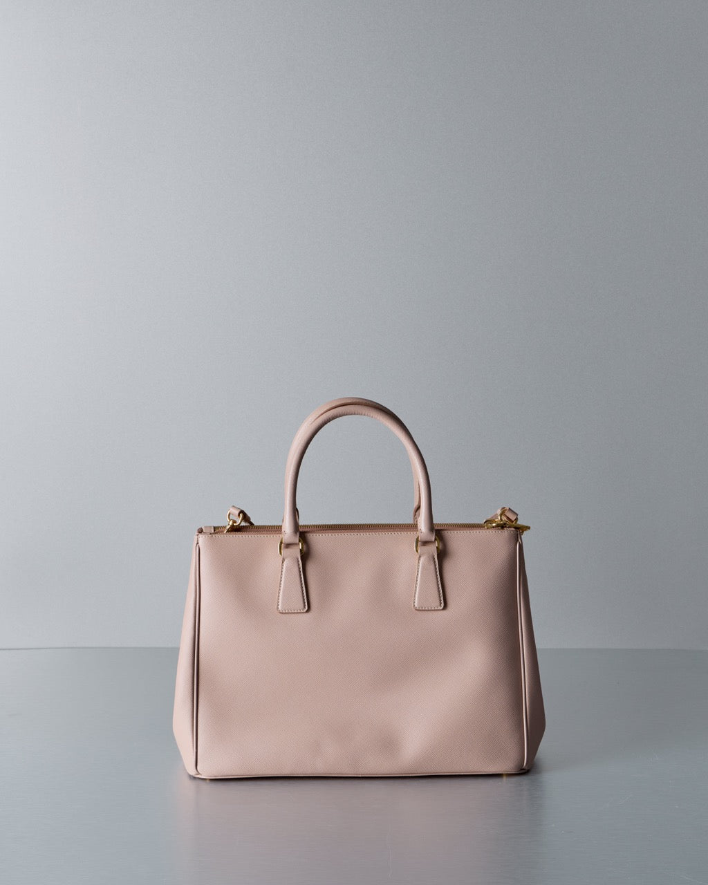 Beige Prada handbag on a gray background