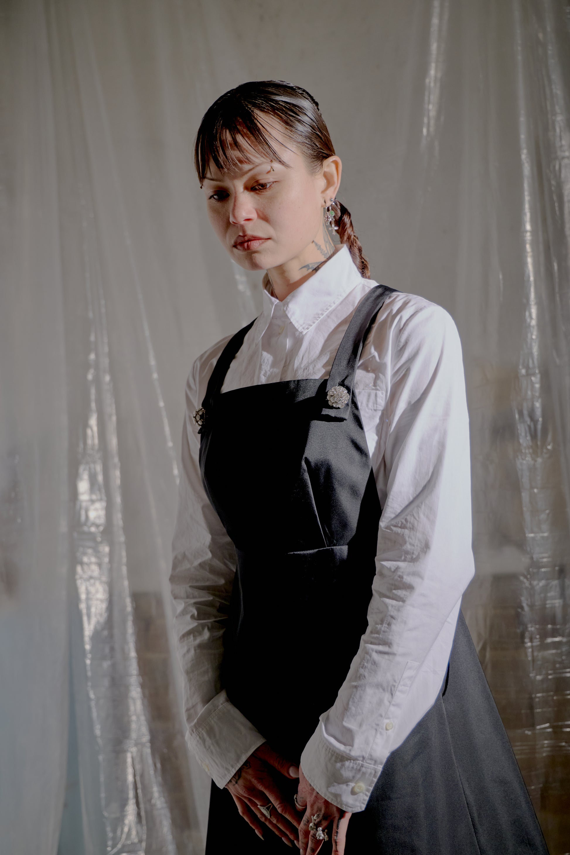 Person wearing a white blouse and black Prada dress against a neutral background