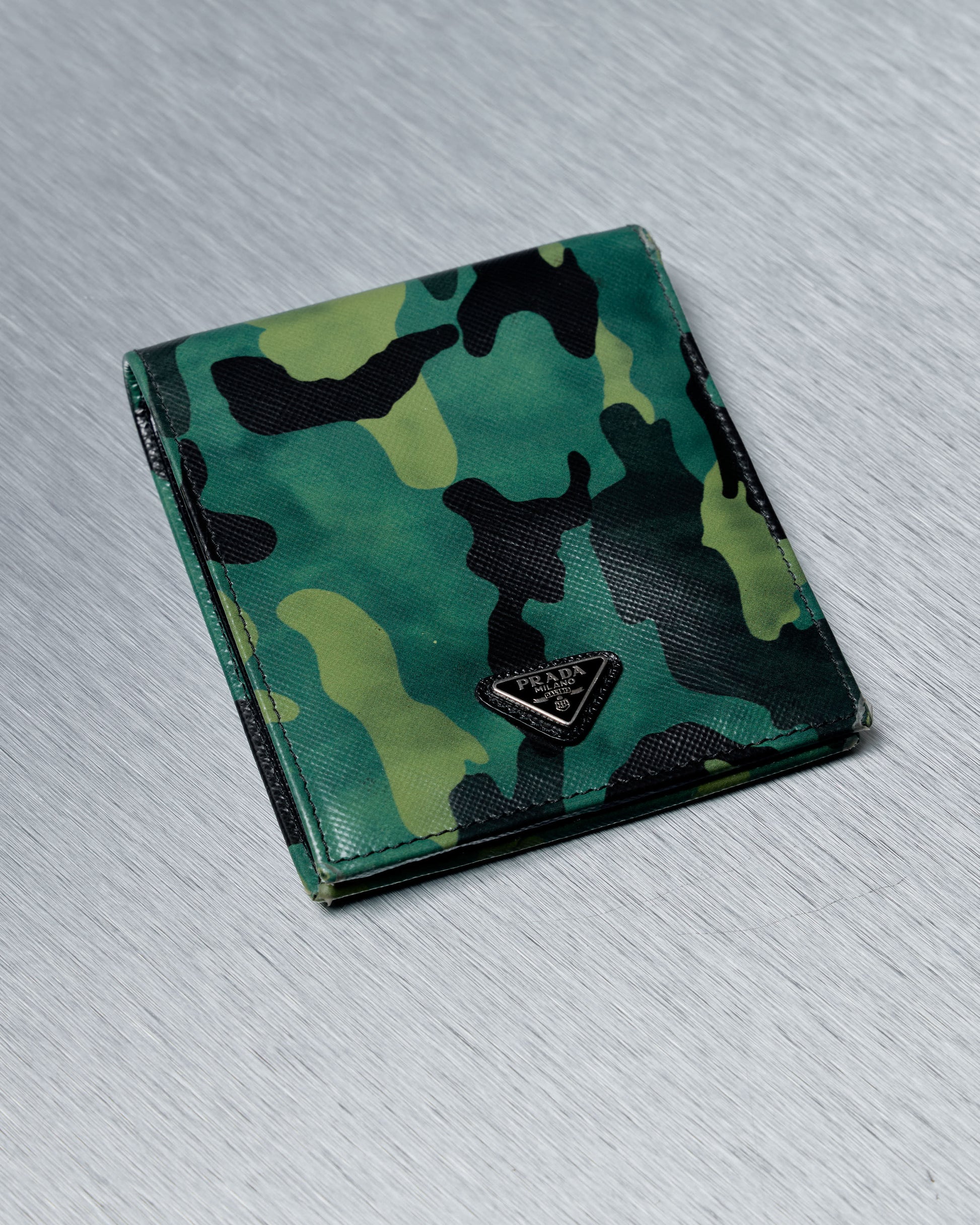 Camouflage-patterned green Prada wallet with a brand logo on a light gray background