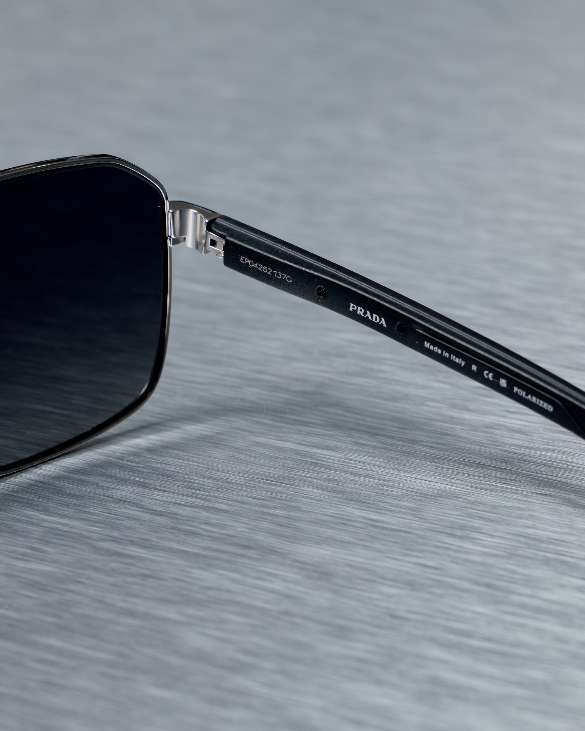 Close-up of a Prada sunglasses on a textured gray background