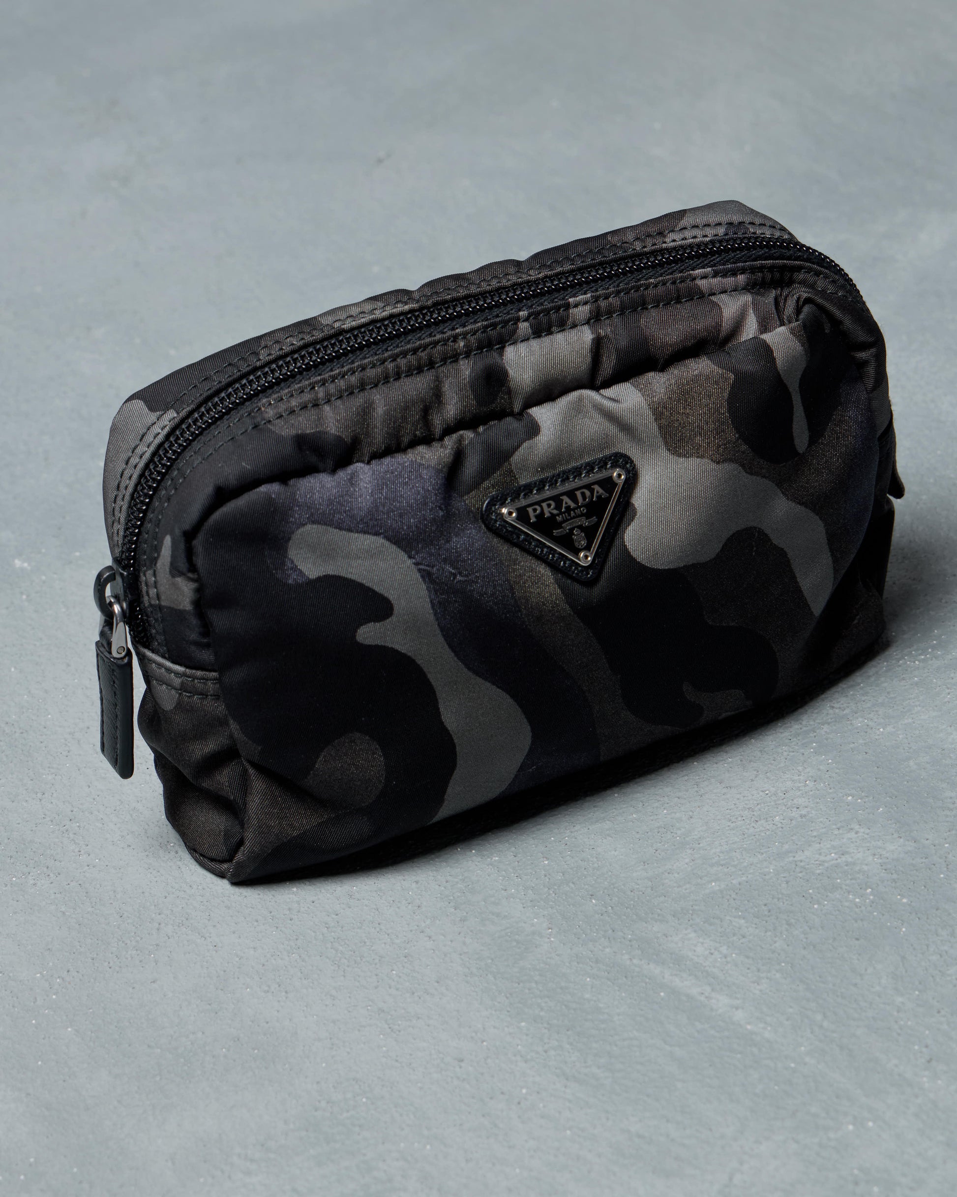 Prada Camouflage-patterned pouch with a brand logo on a gray background