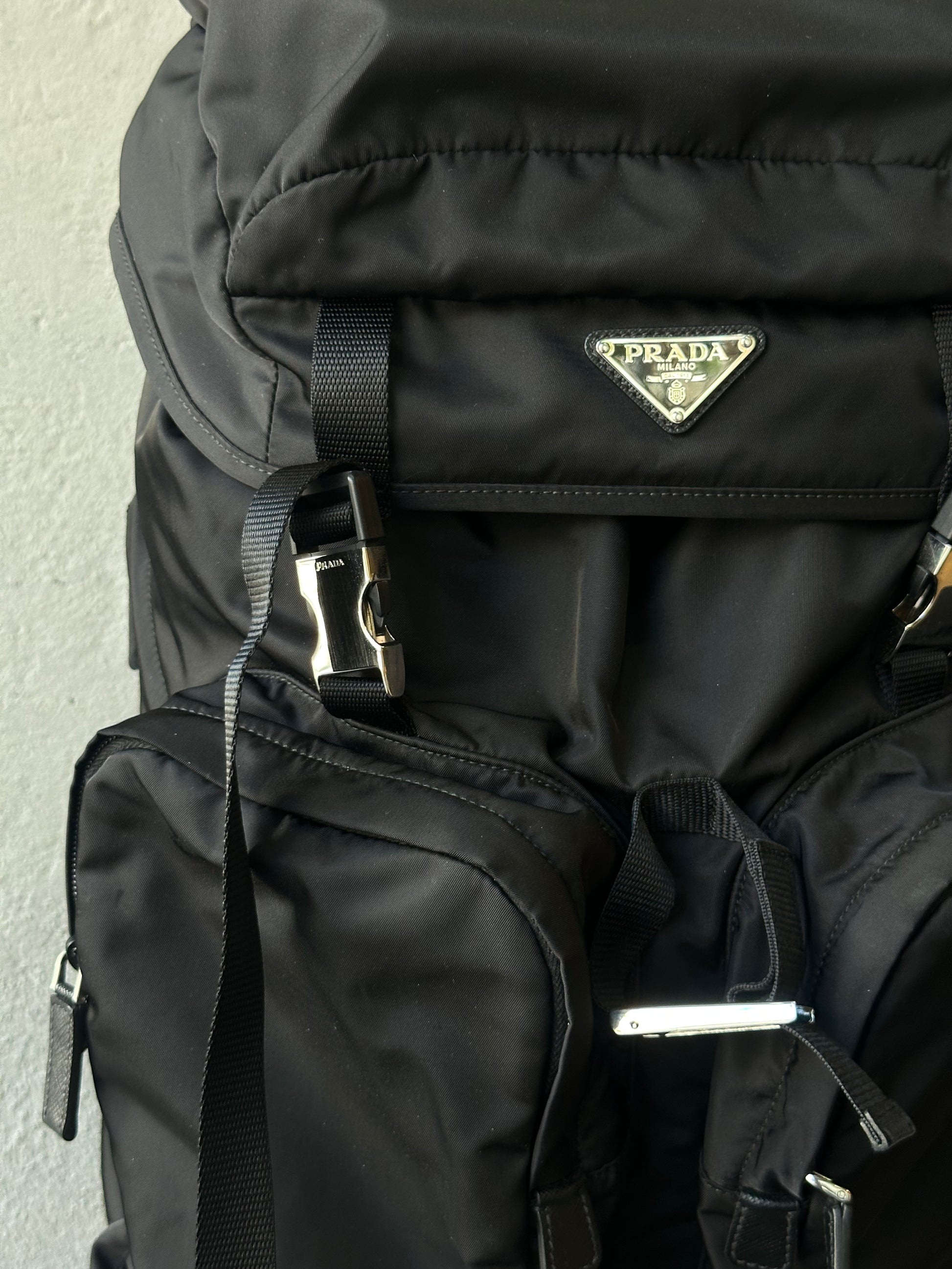 Black Prada backpack with visible logo on a light gray background