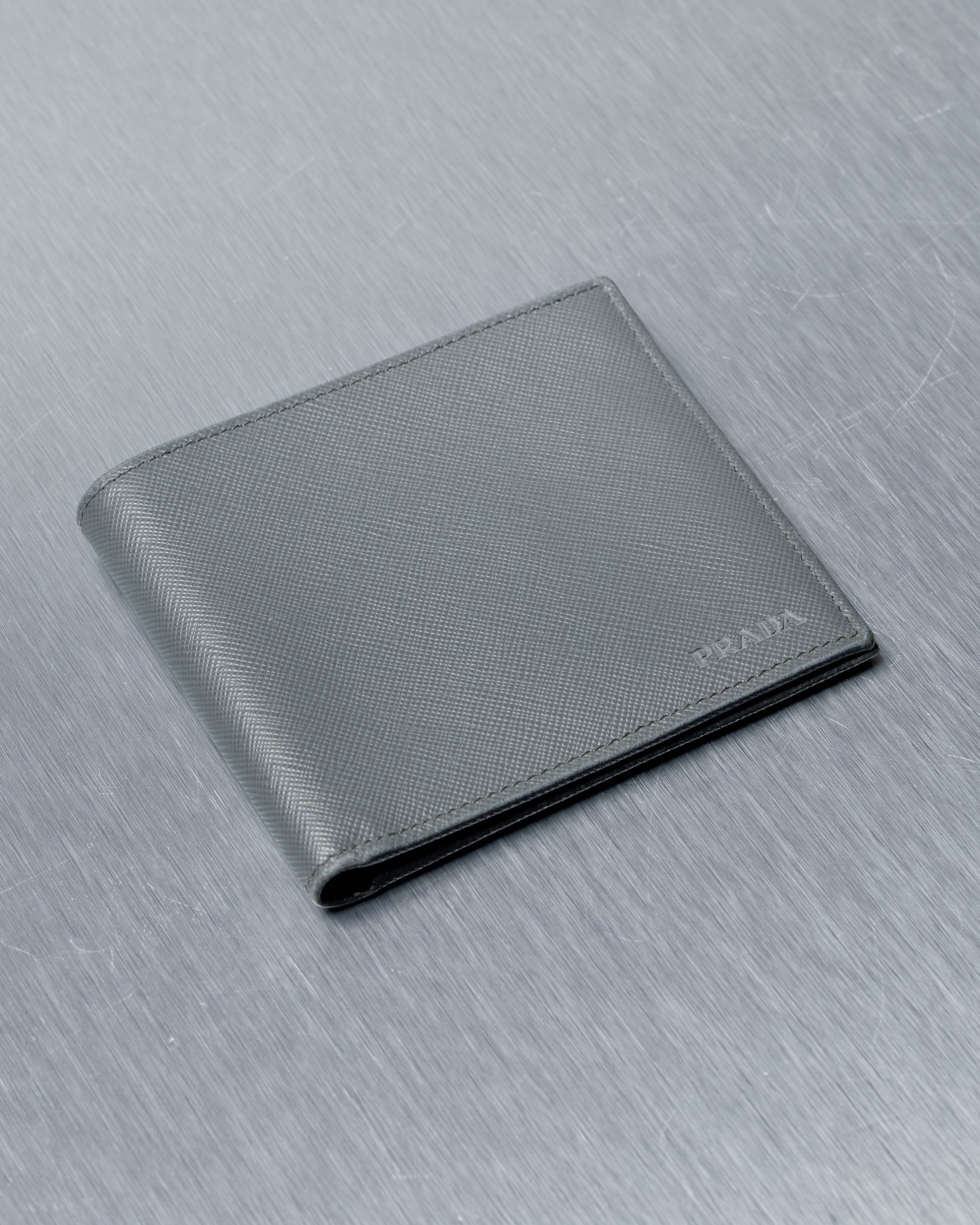 Gray Prada wallet on a textured gray surface