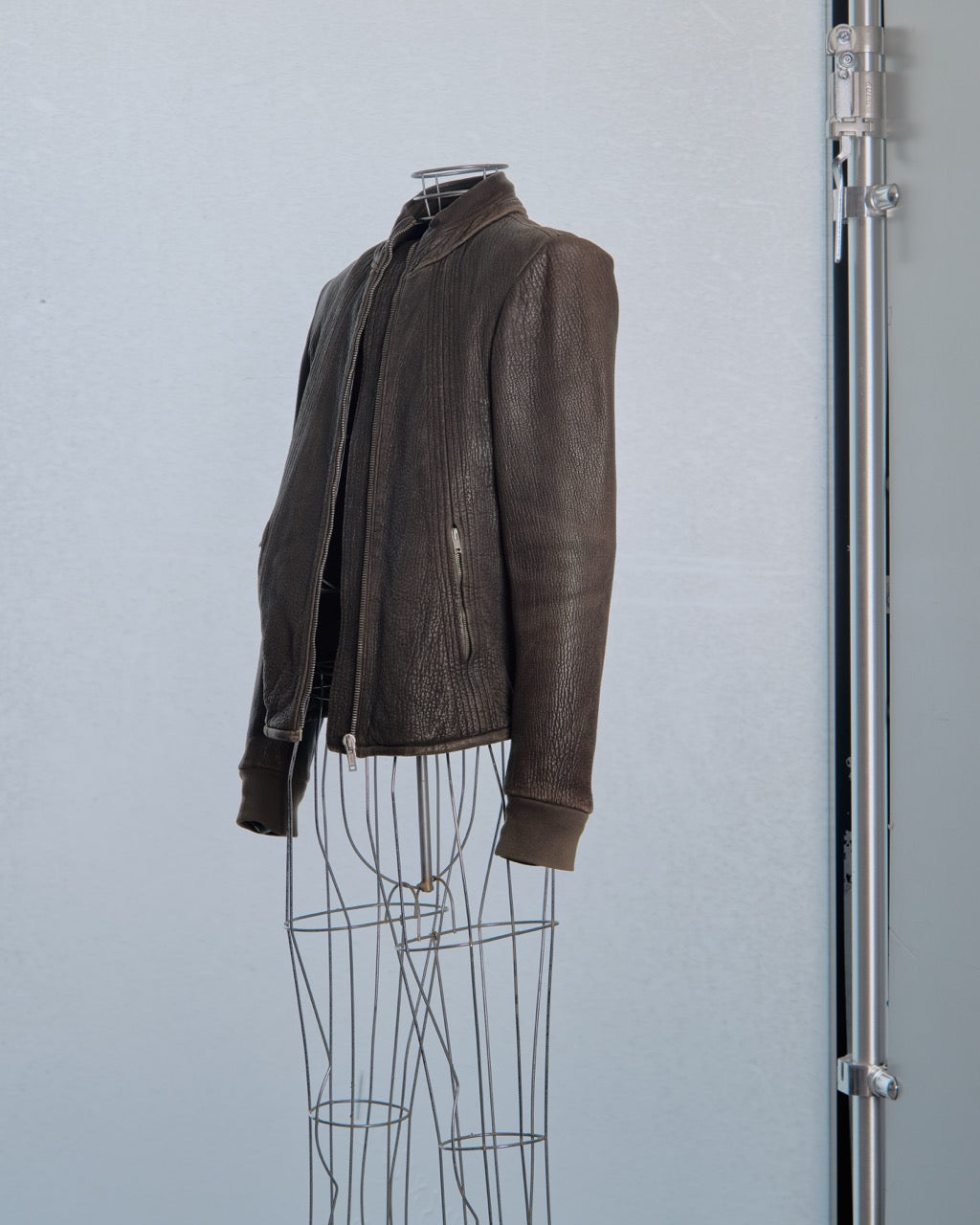 Brown leather Rick Owens jacket on a mannequin against a light gray background