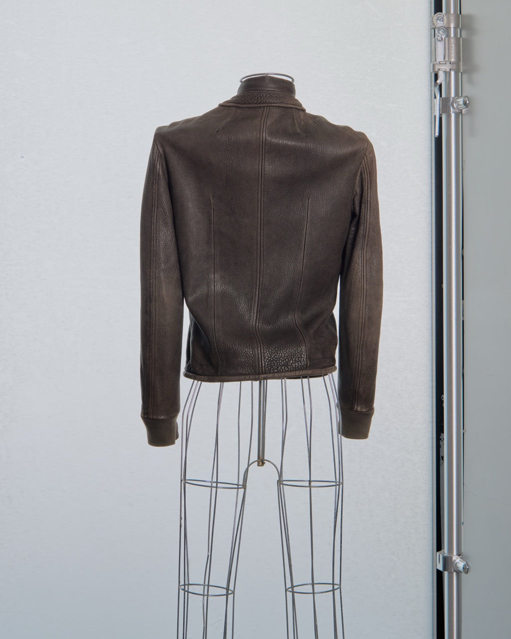 Brown leather Rick Owens jacket on a mannequin against a plain background